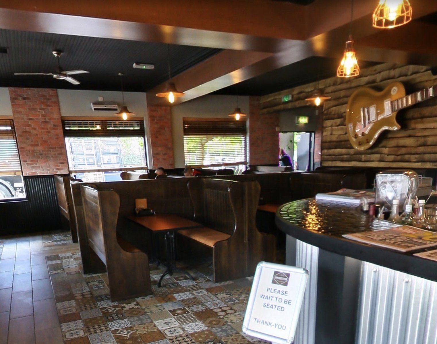 The inside of a restaurant with a guitar on the wall