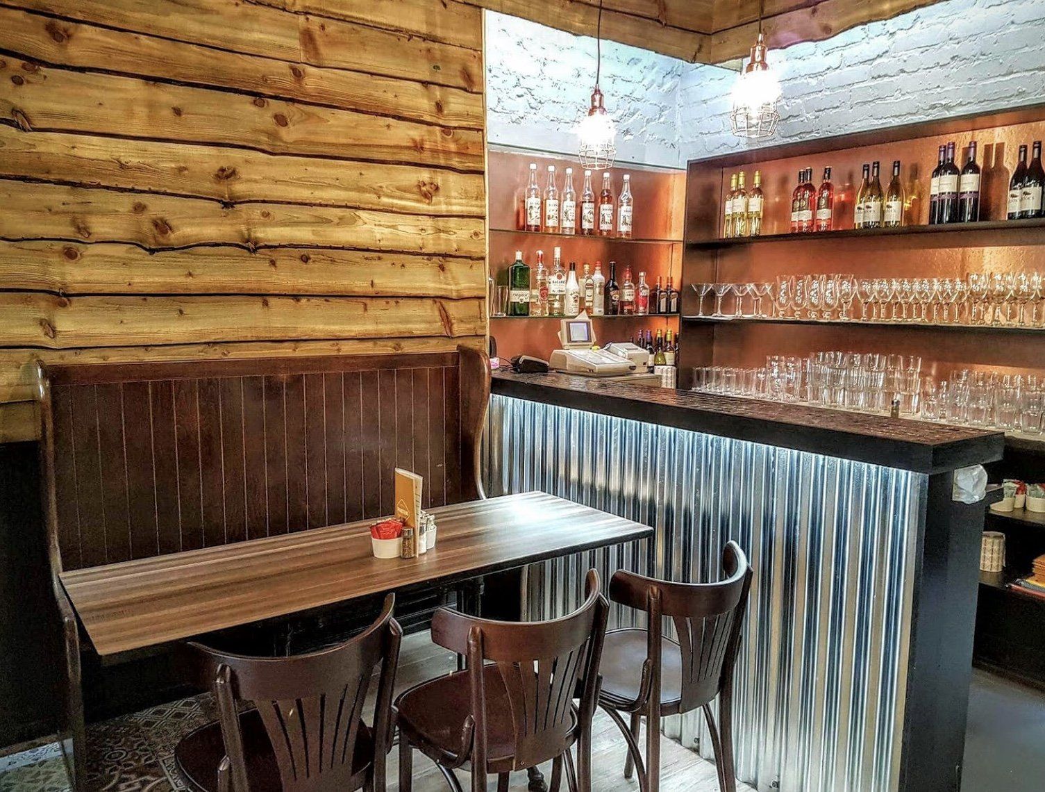 A restaurant with tables and chairs and a bar.