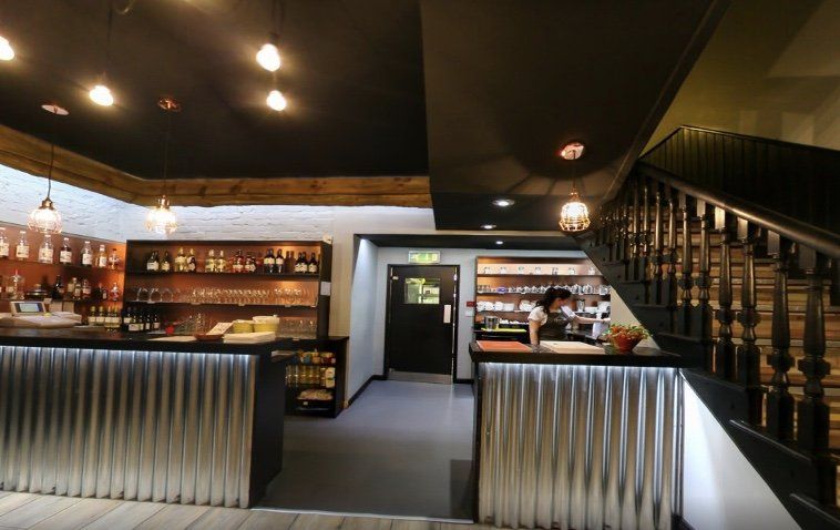 The inside of a restaurant with a bar and stairs