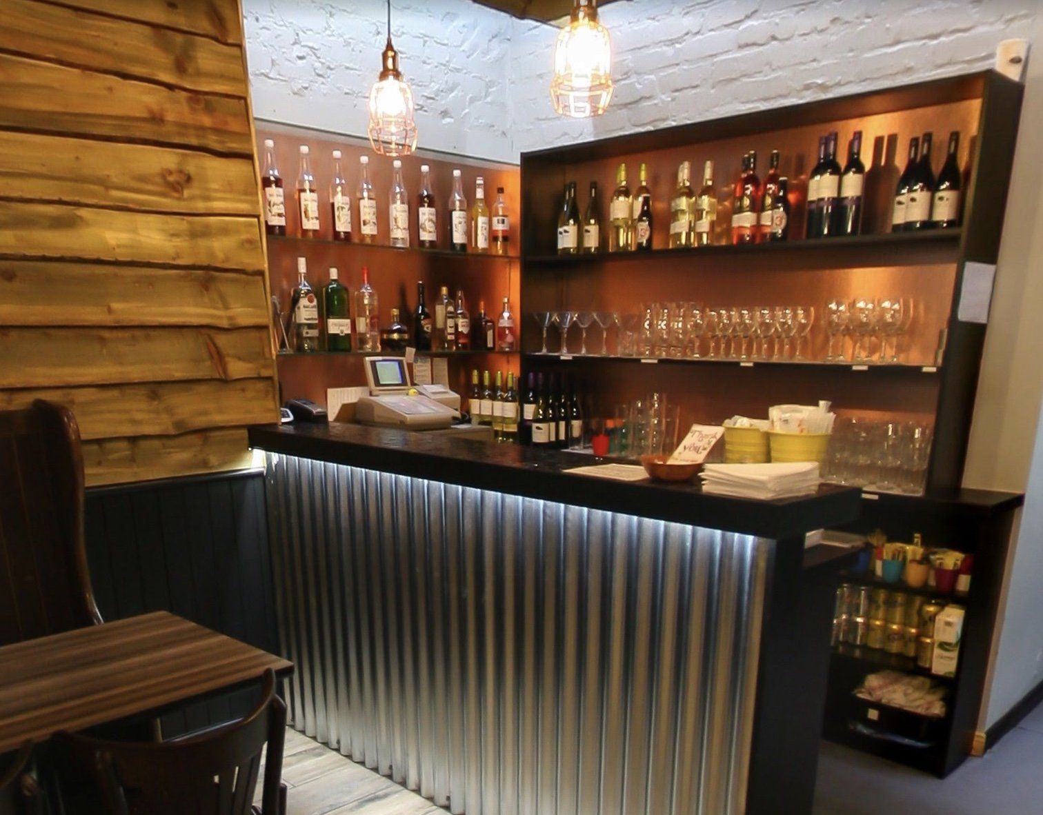 A bar with a lot of bottles and glasses on it