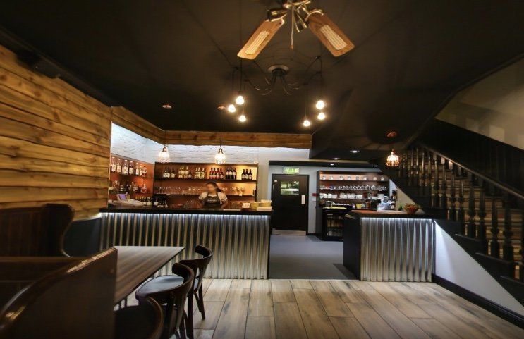 A restaurant with tables and chairs and a ceiling fan.