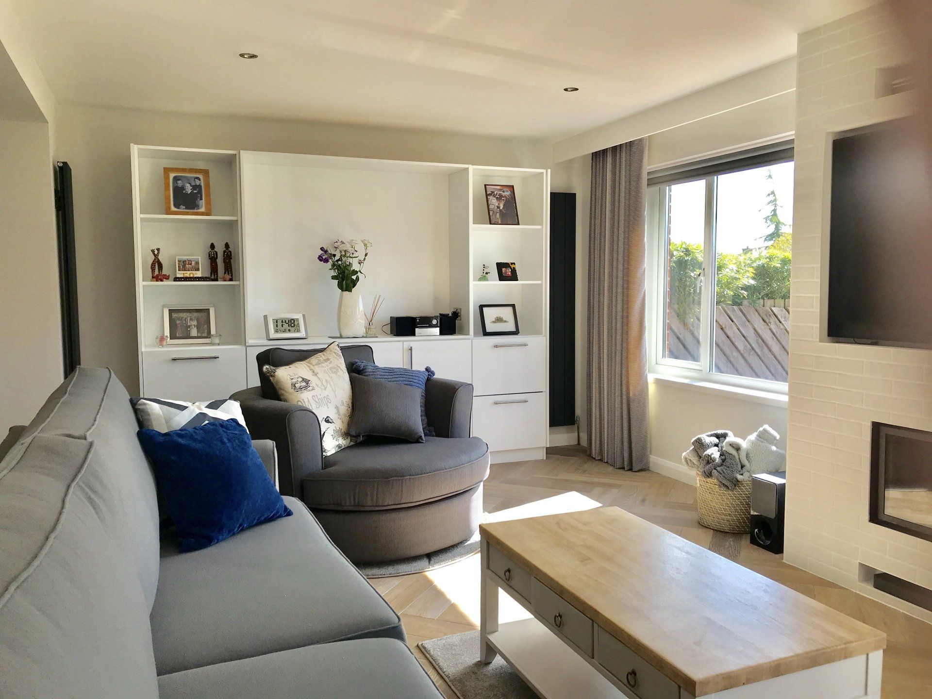 A living room with a couch , chair , coffee table and television.