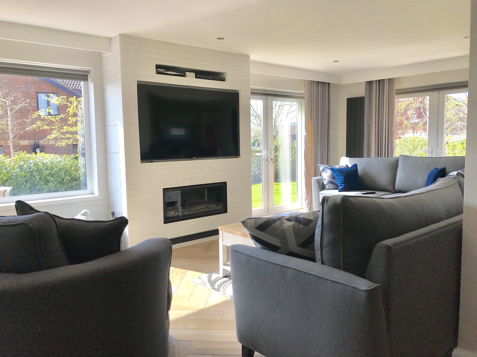 A living room with a couch , chair , television and fireplace.
