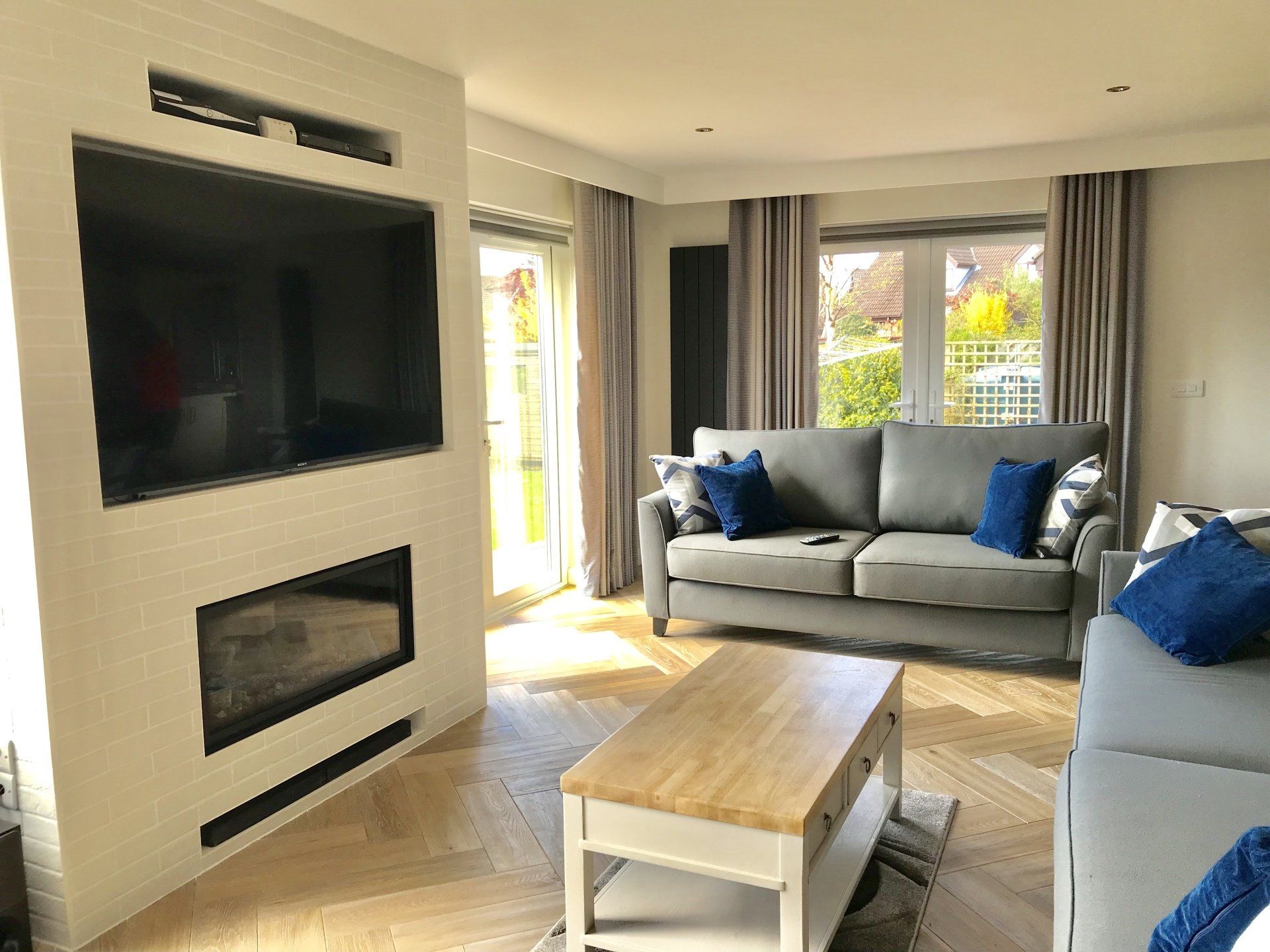 A living room with a couch , coffee table , television and fireplace.