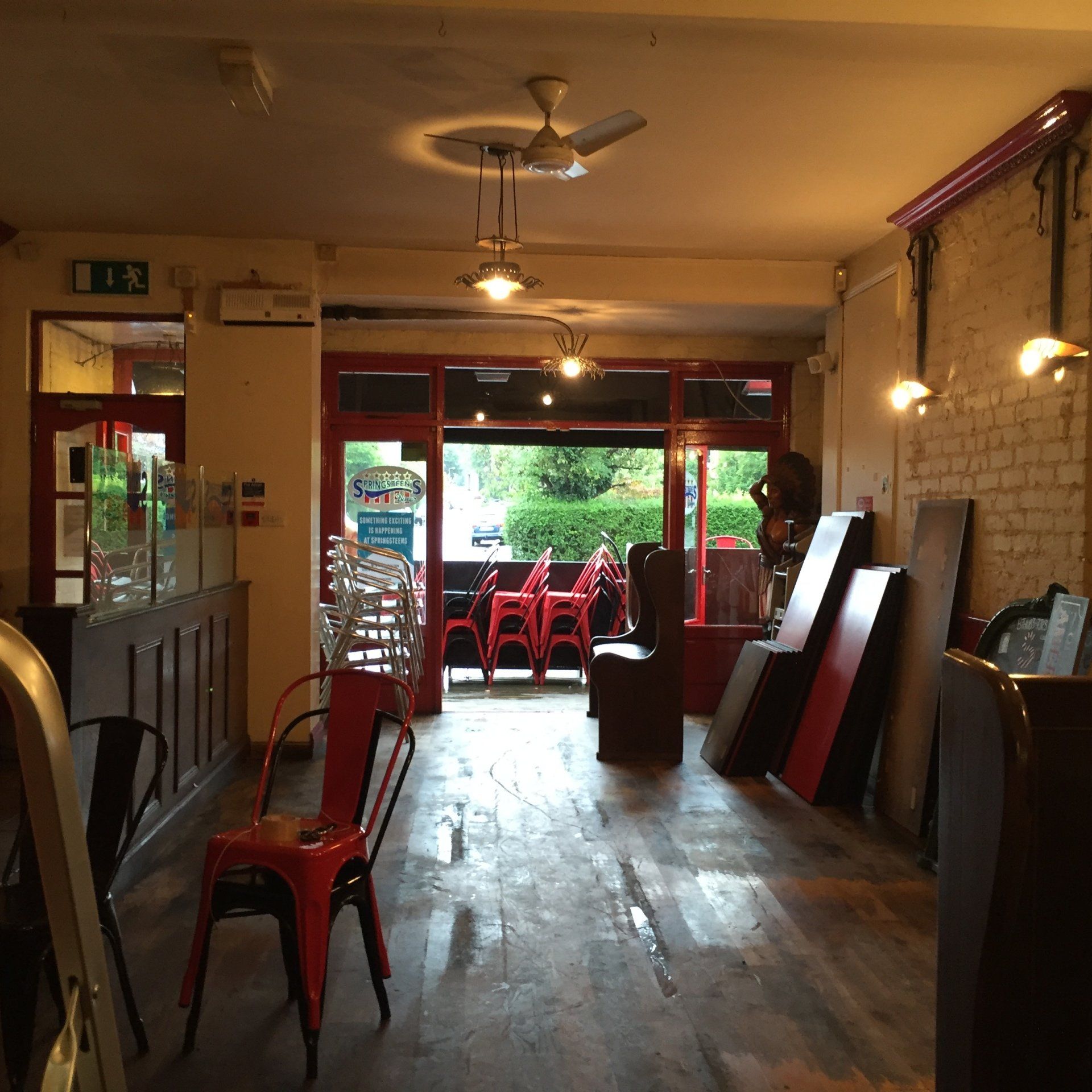 A restaurant with red chairs and a sign that says exit