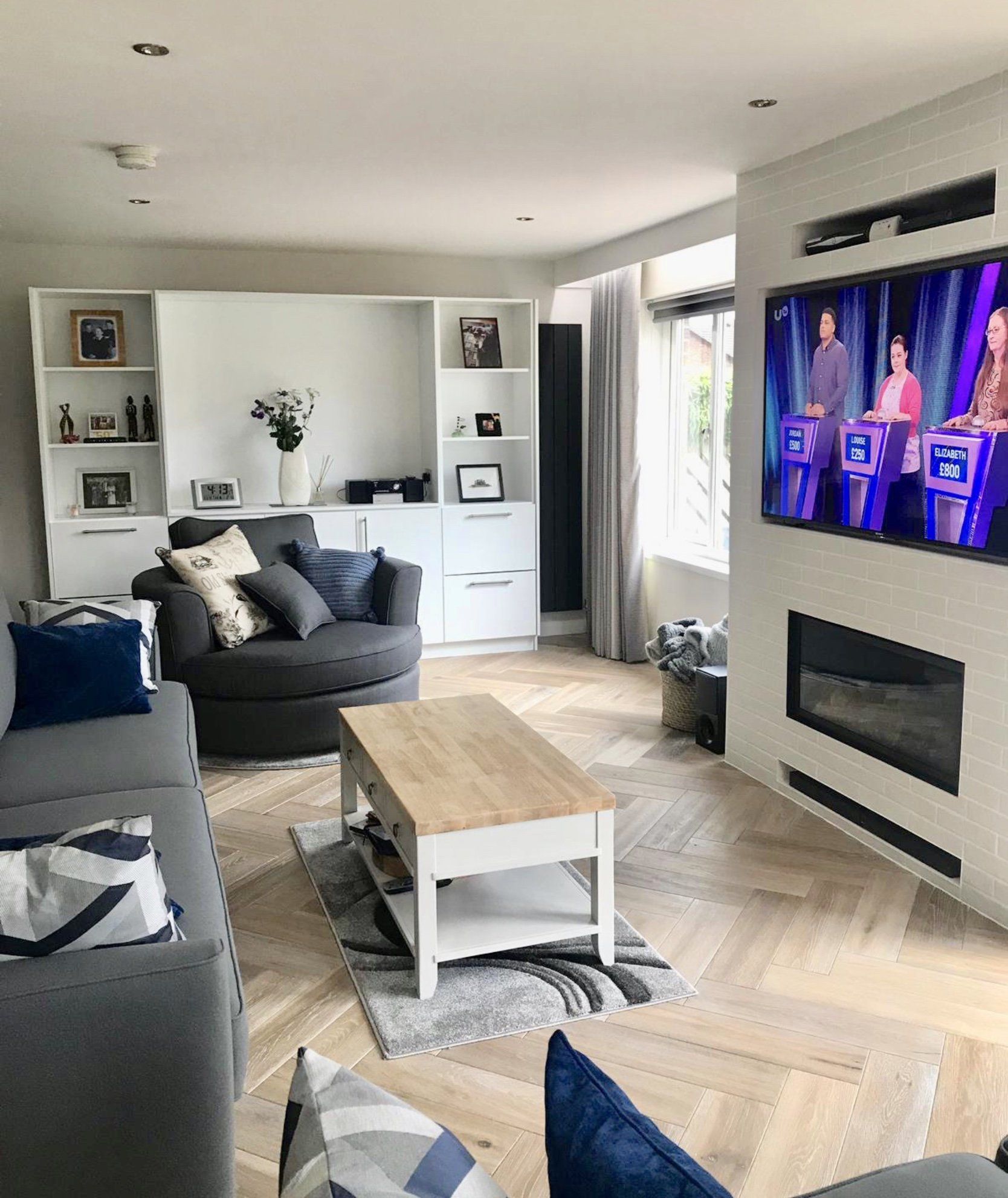 A living room with a couch , chair , coffee table and television.