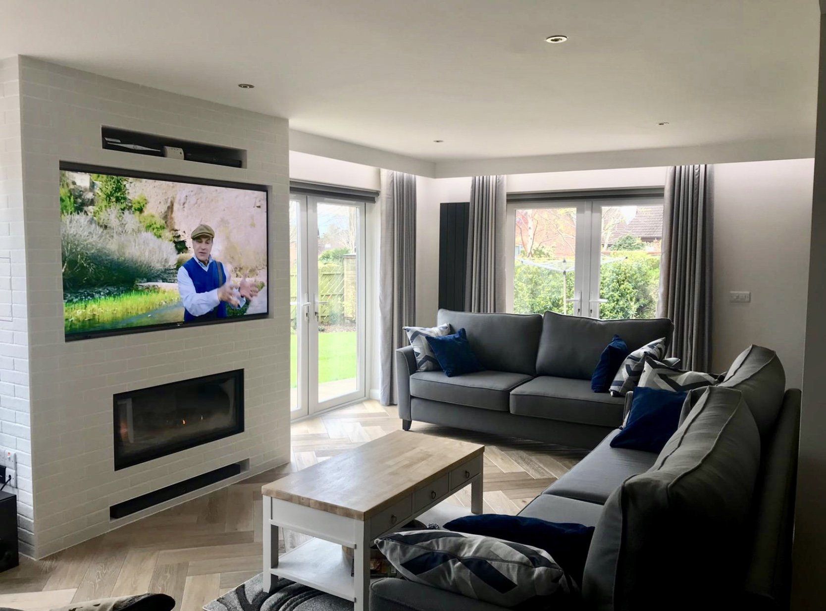 A living room with a couch , fireplace and television.