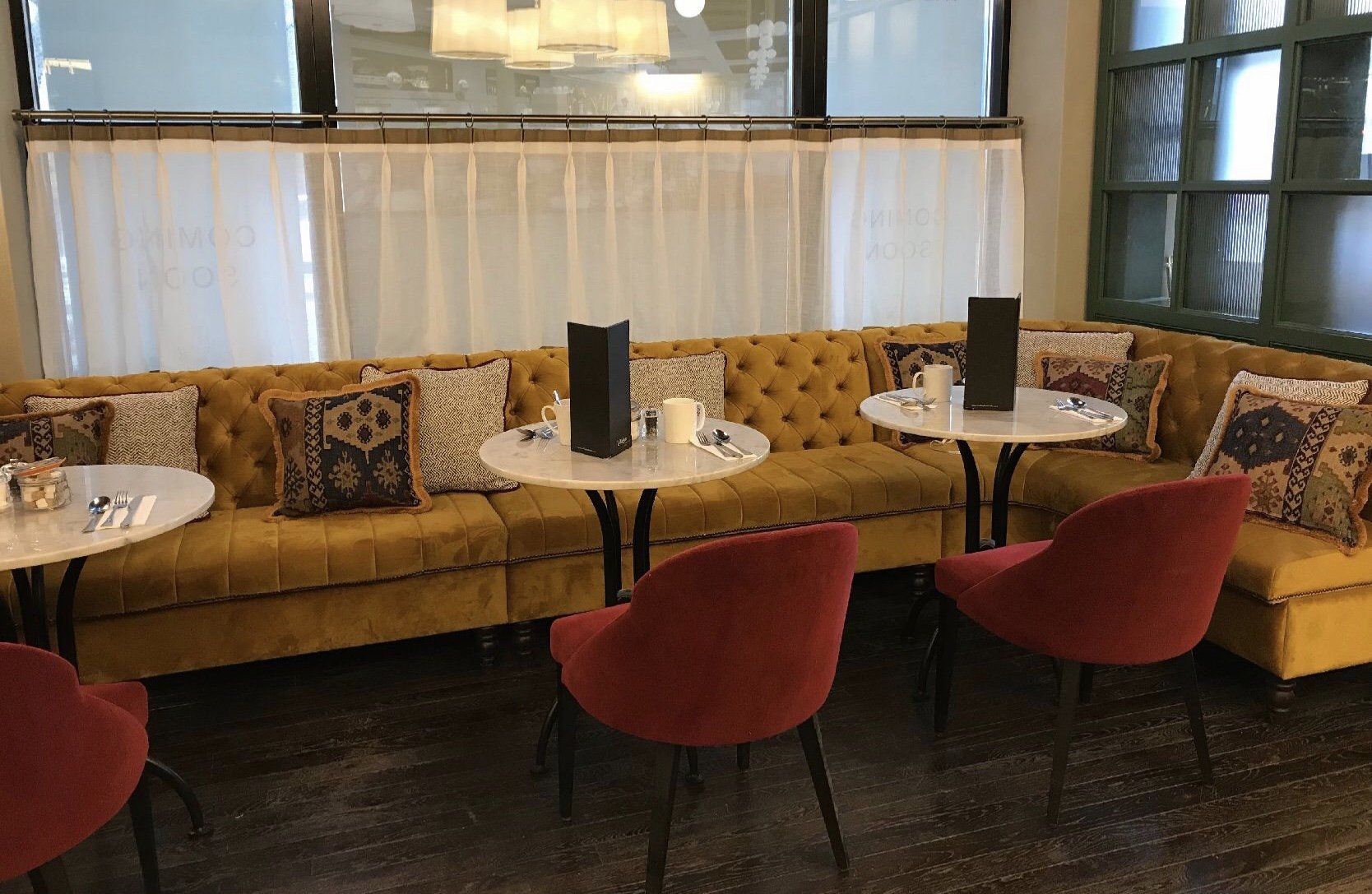 There are tables and chairs in the room with a couch.