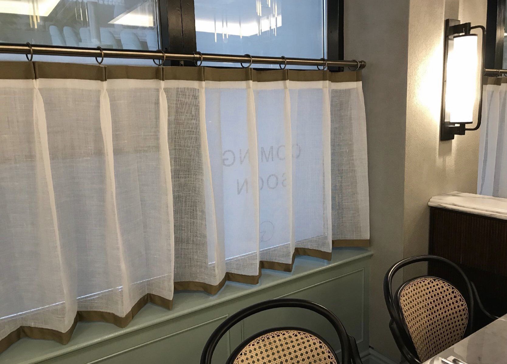 A dining room with a table and chairs and curtains