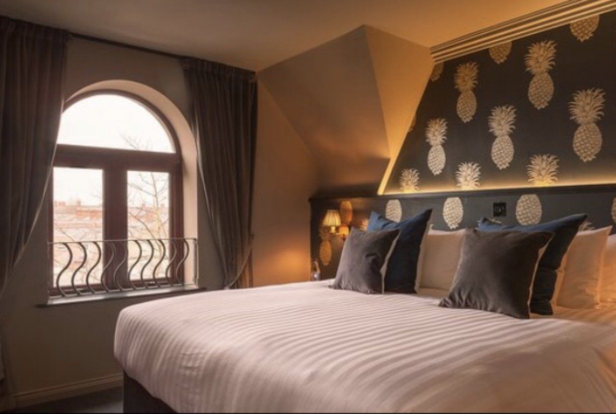 A hotel room with a large bed and pineapple wallpaper