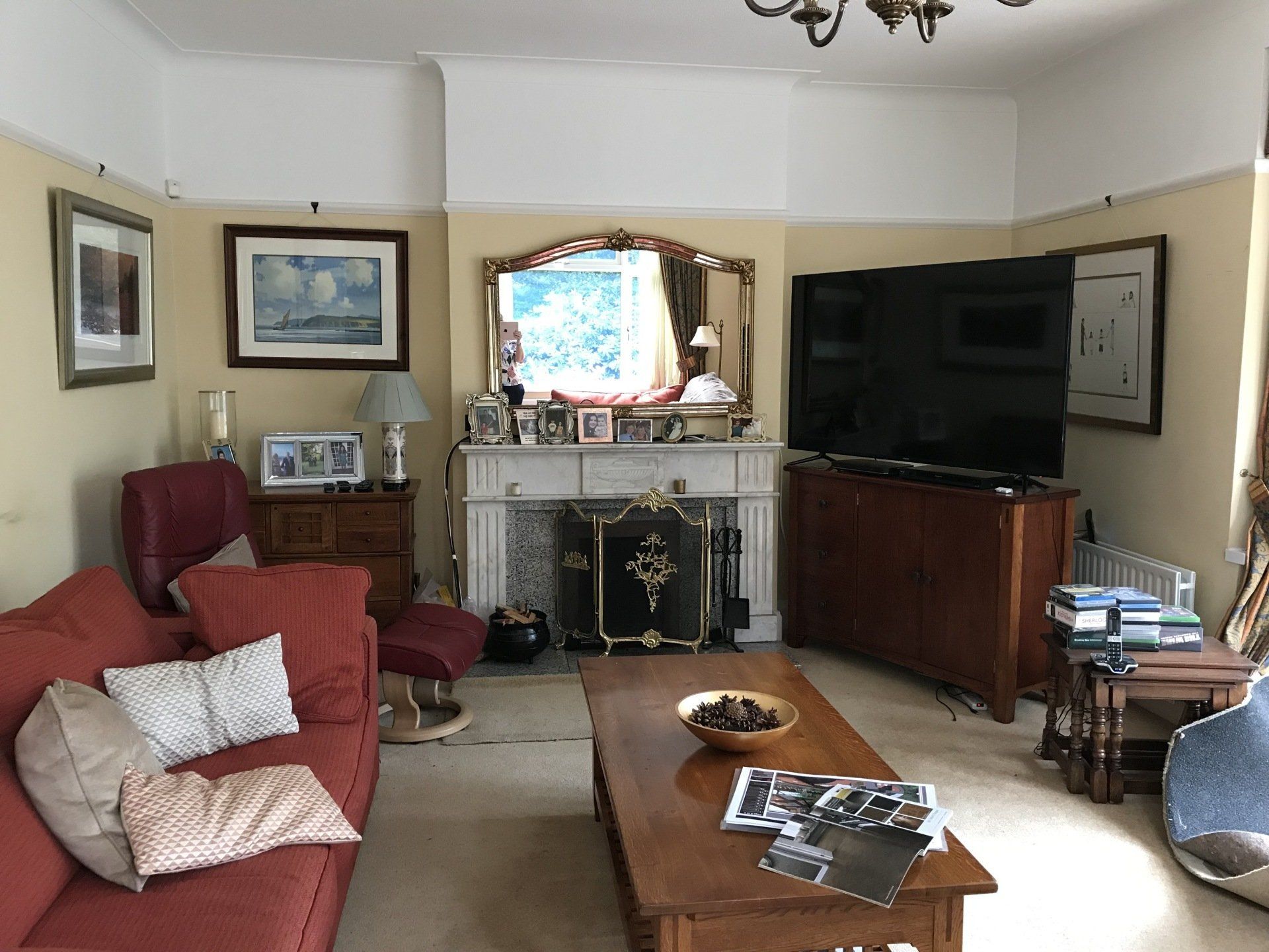 A living room with a couch , table , fireplace and television.