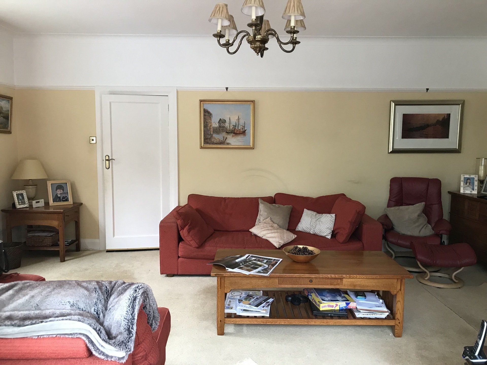 A living room with a red couch and a wooden coffee table