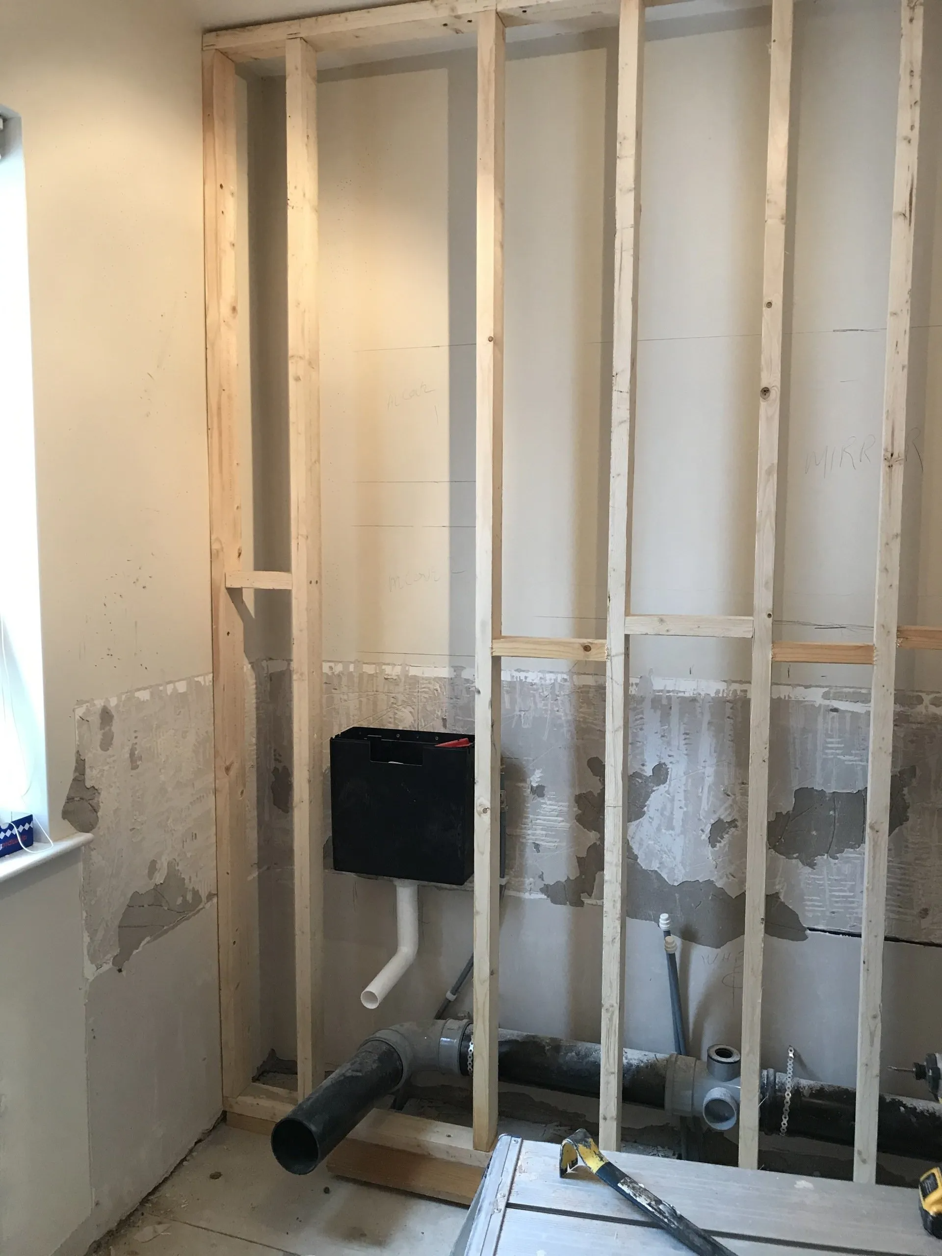 A bathroom is being remodeled and the wall is being built with wooden beams.