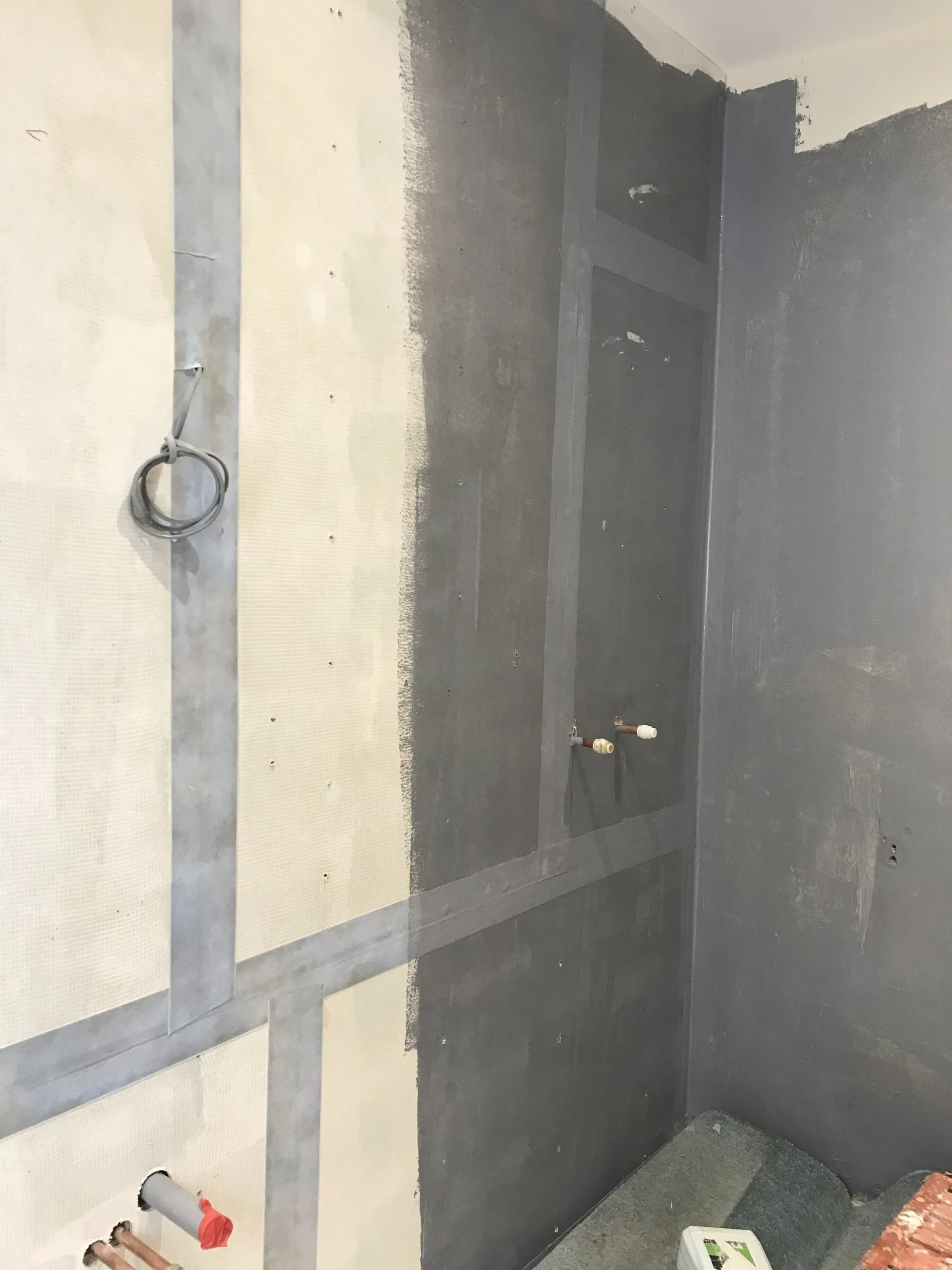 A bathroom is being remodeled and a wall is being painted.