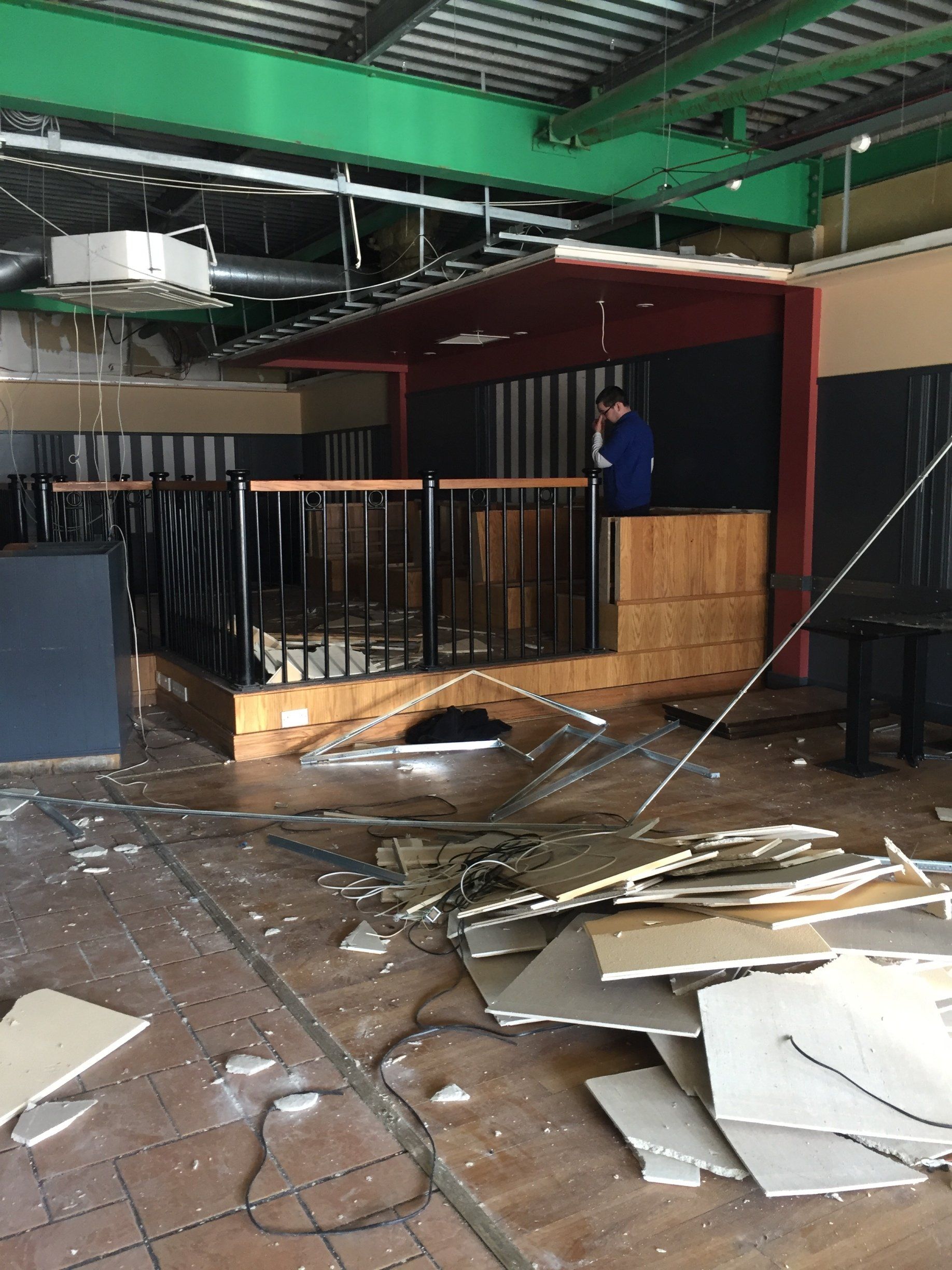 A man is standing on a balcony in an empty building.