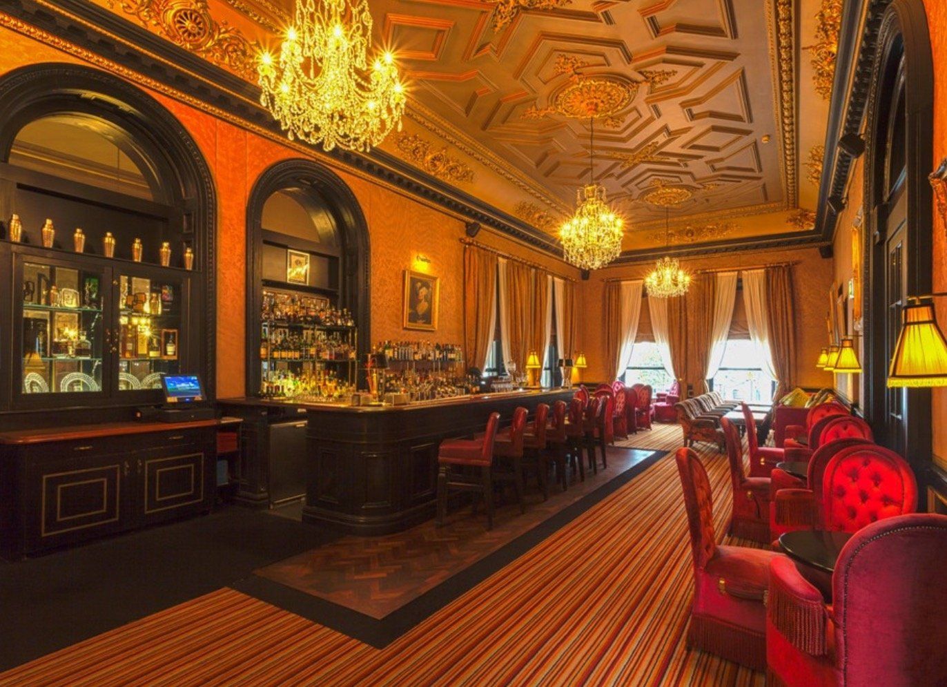 A large room with a bar and chairs in it