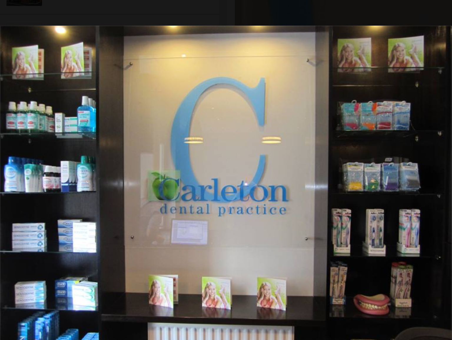 A sign for carleton dental practice hangs on a wall