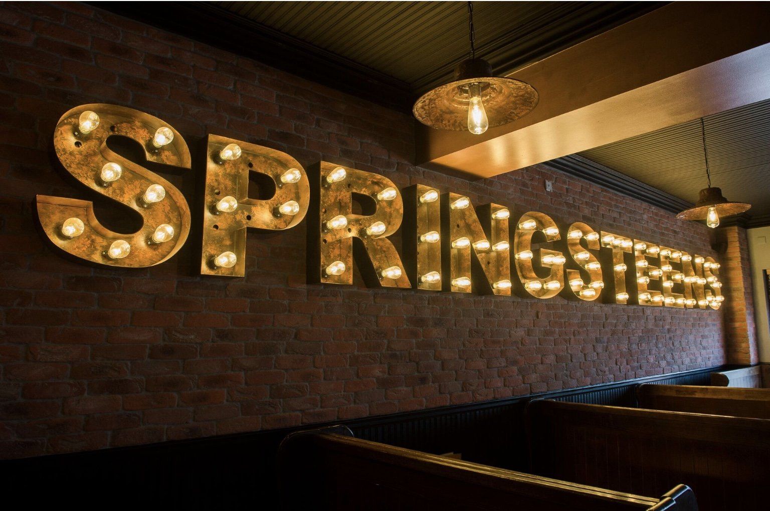 A sign that says springsteen on a brick wall