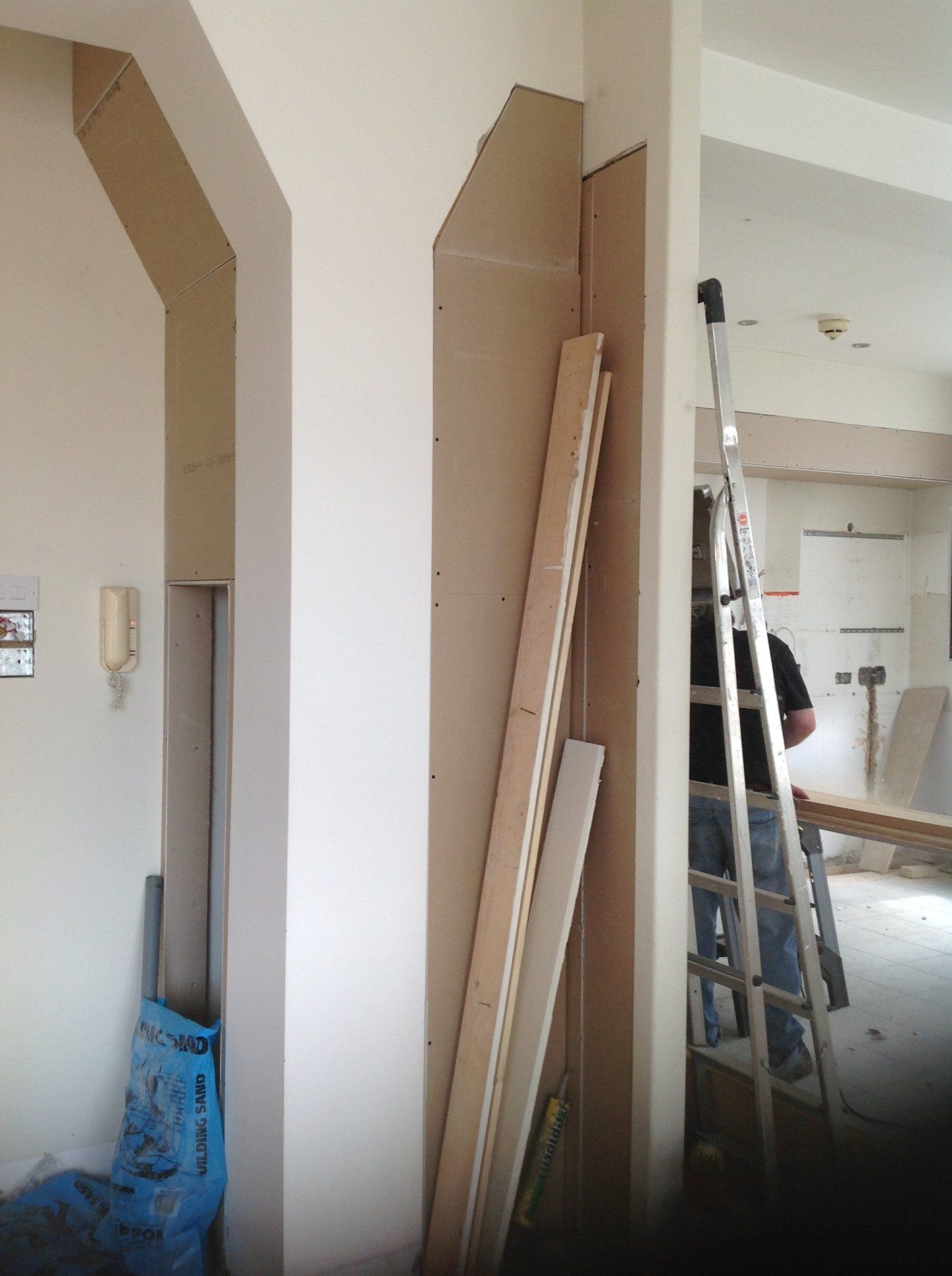 A man standing on a ladder in a room