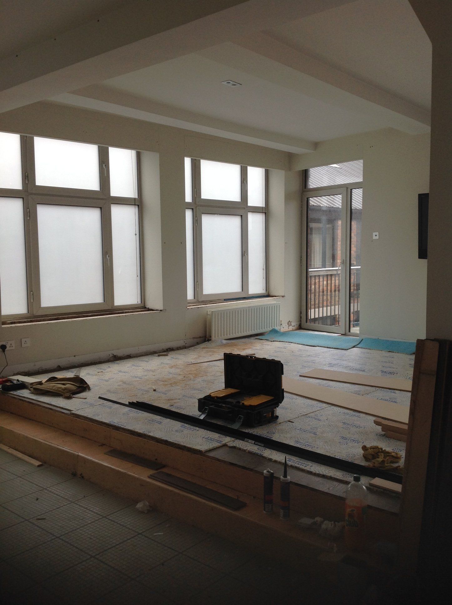 A room with a lot of windows and a briefcase on the floor