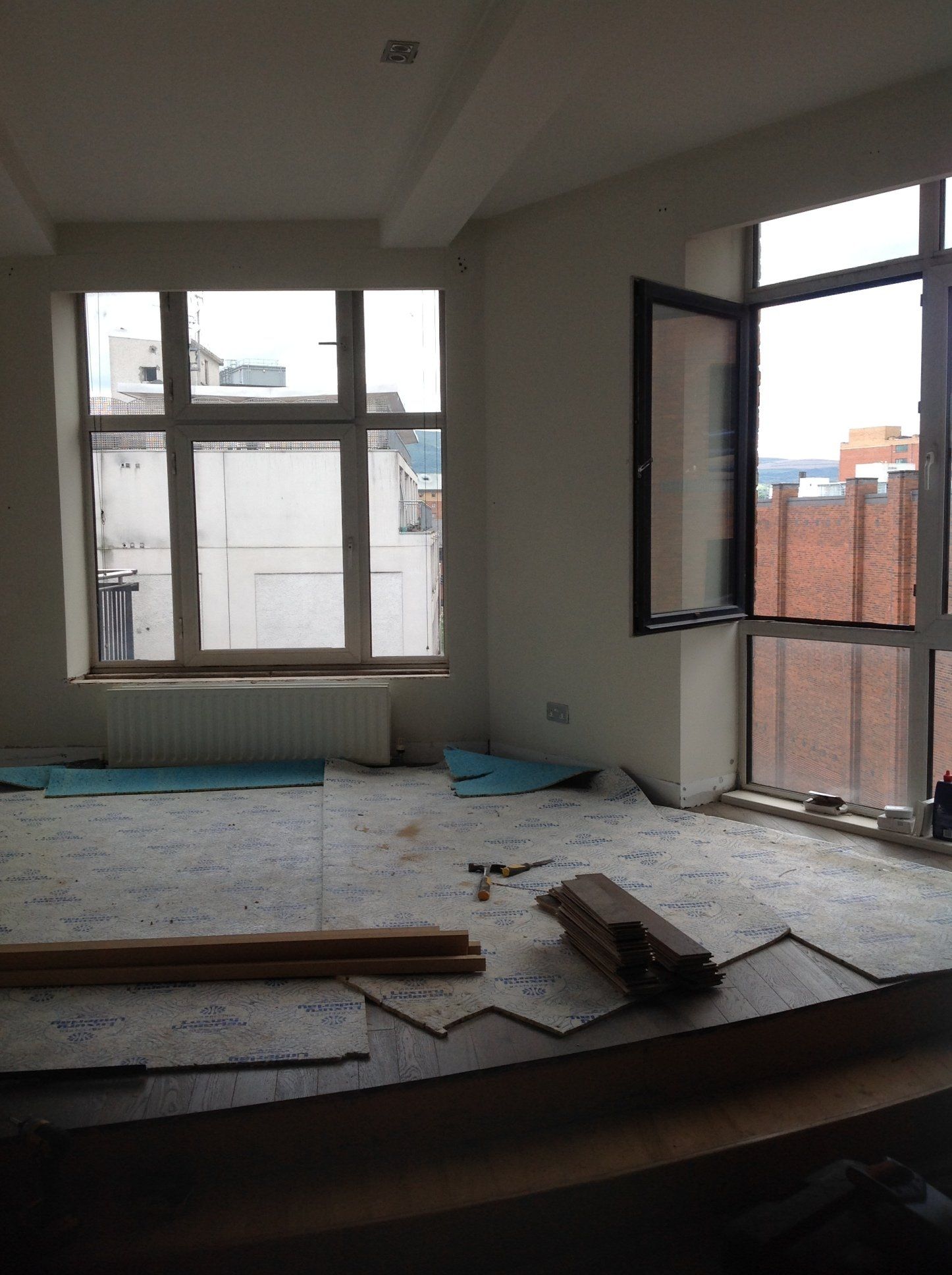 A room with a lot of windows and a hammer on the floor