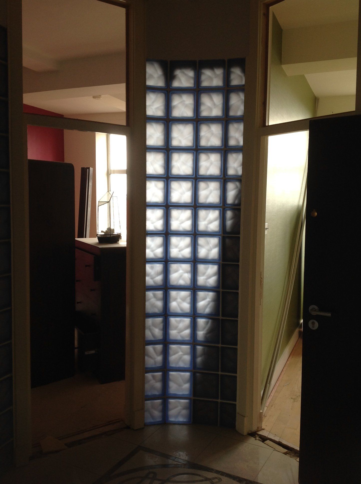 A hallway with a glass block wall between two doors