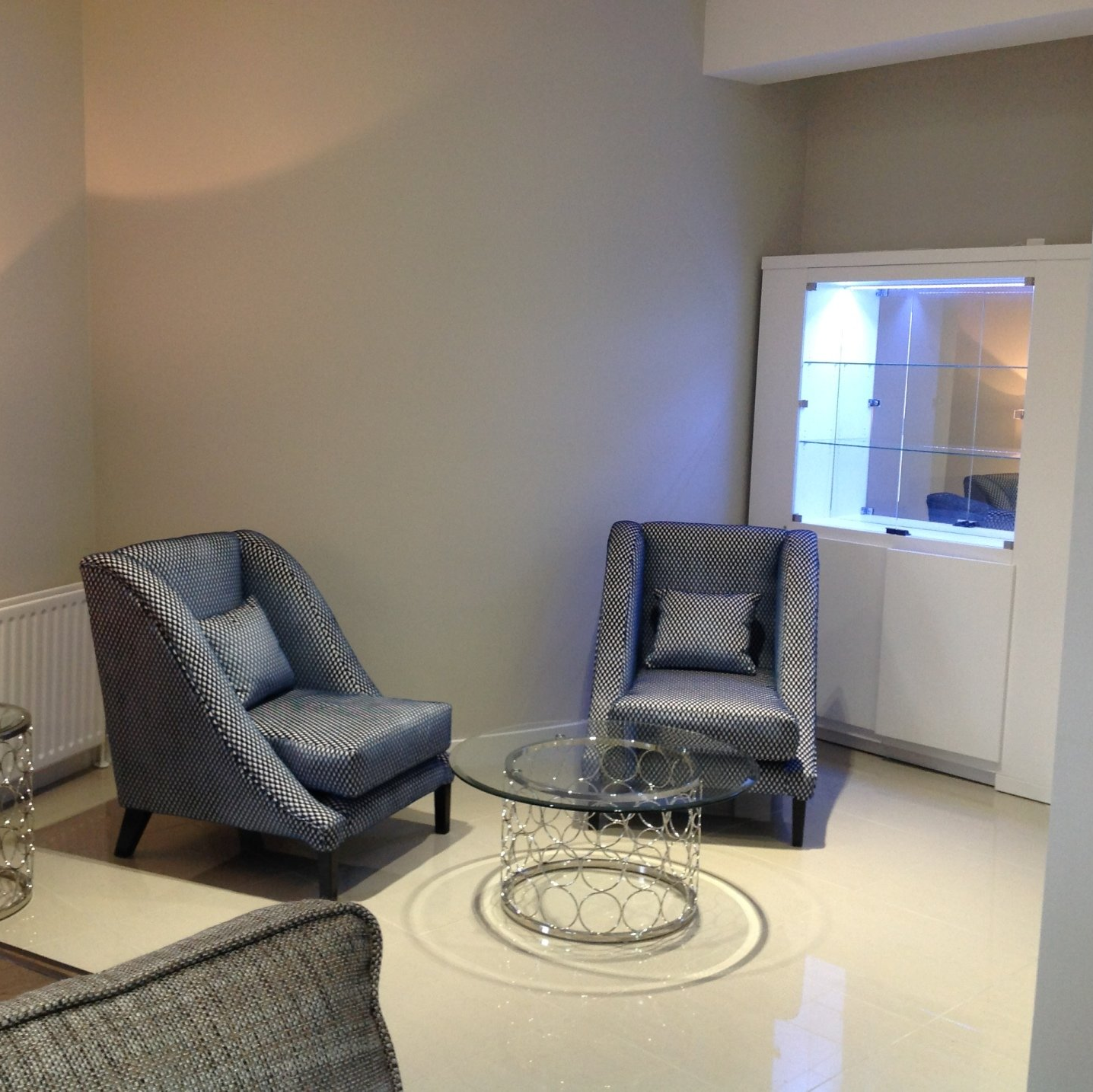 A living room with two chairs and a glass table