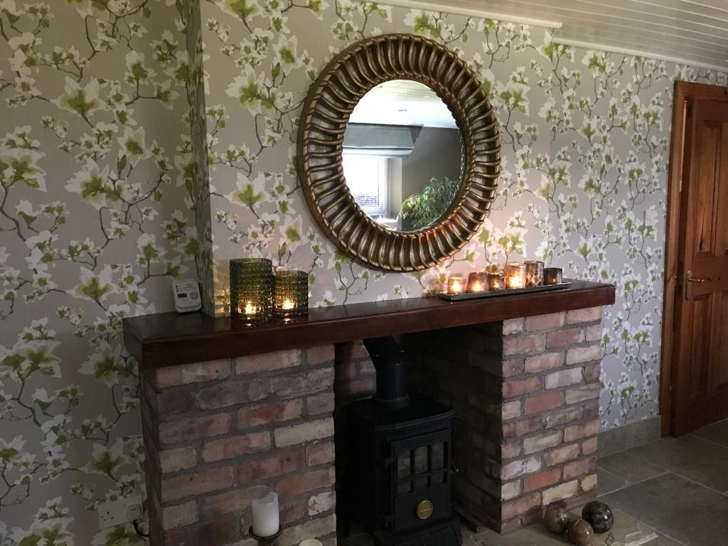A living room with a fireplace and a mirror on the wall.