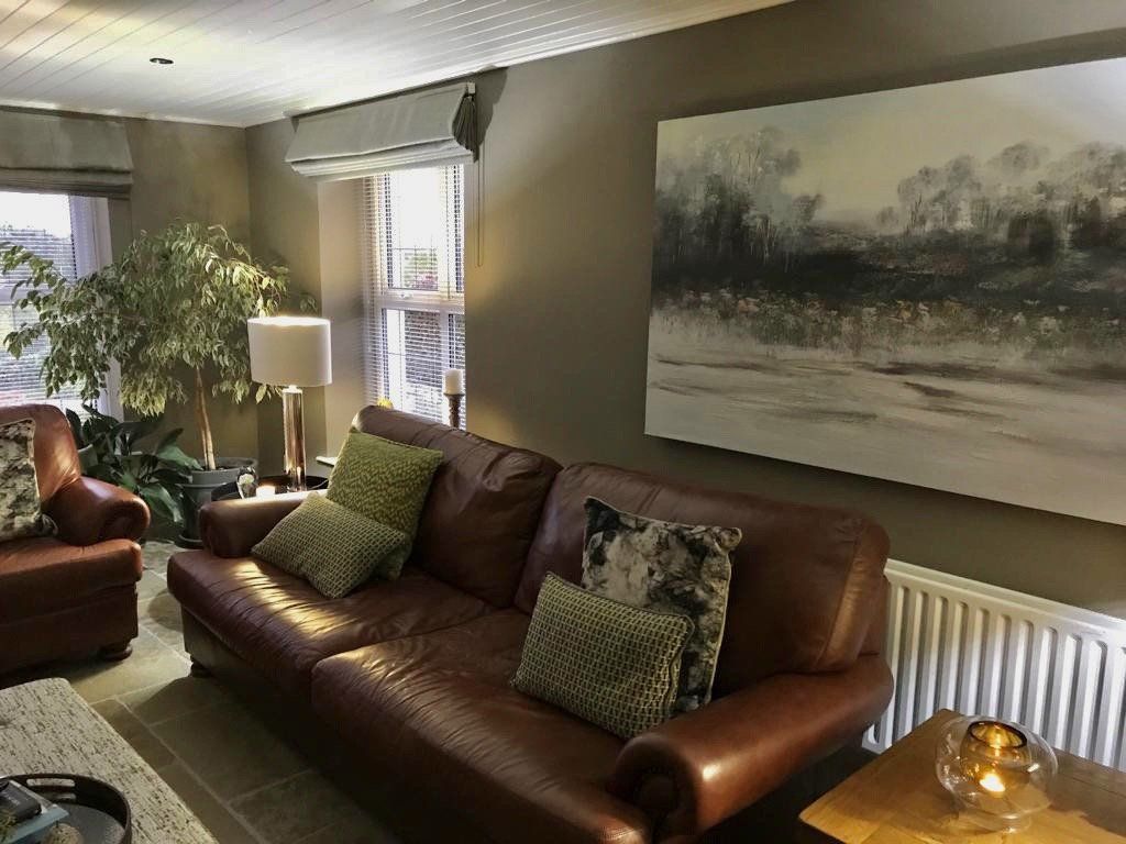 There is a painting on the wall above the couch in the living room.
