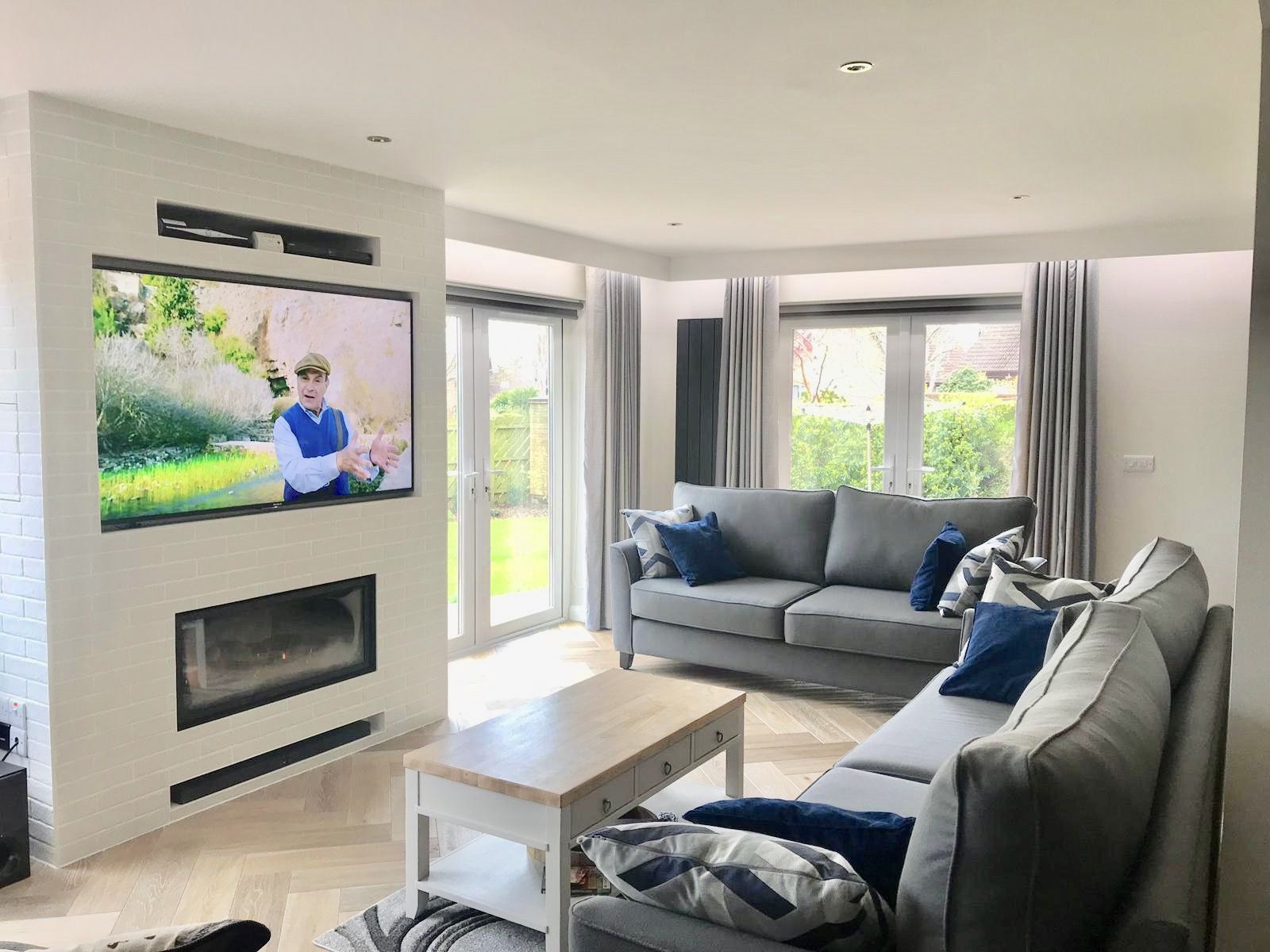 A living room with a couch , fireplace and television.