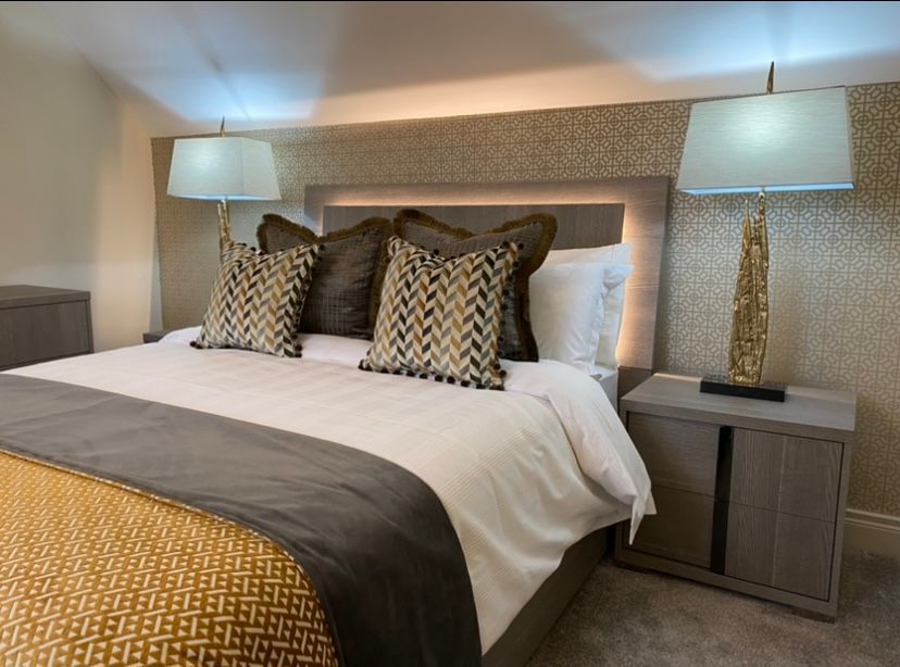 A bedroom with a king size bed and two lamps