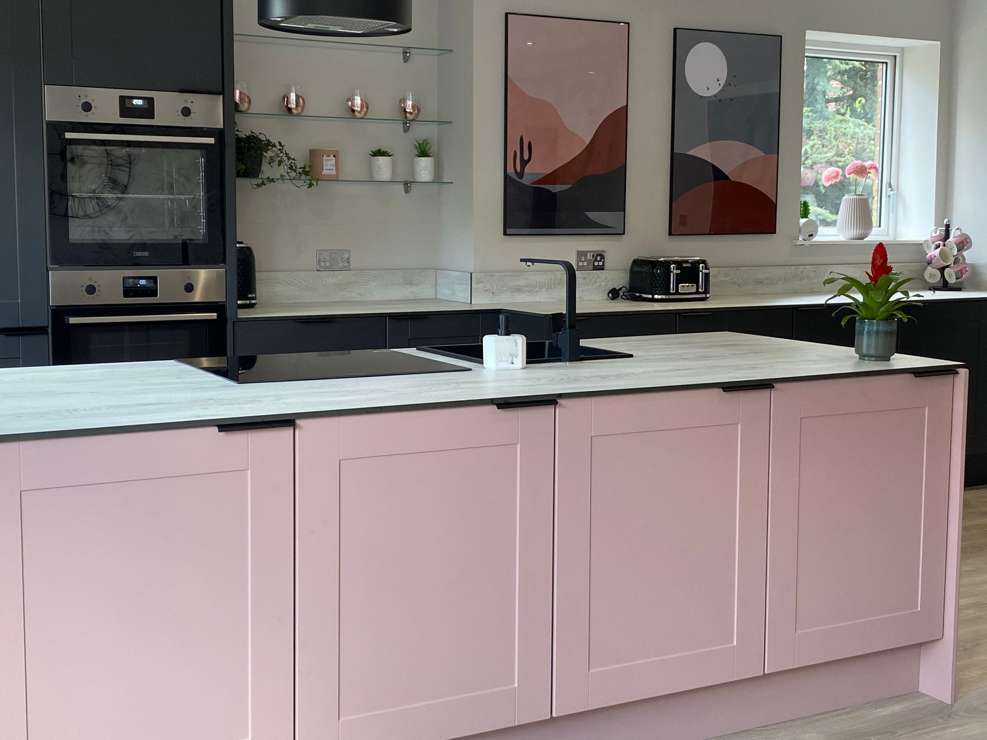 A kitchen with pink cabinets and a large island.