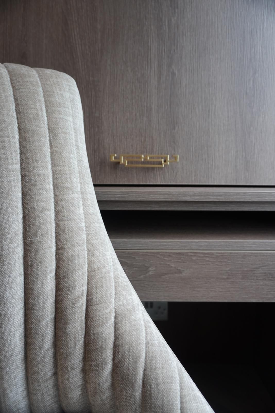 A chair is sitting next to a wooden desk.