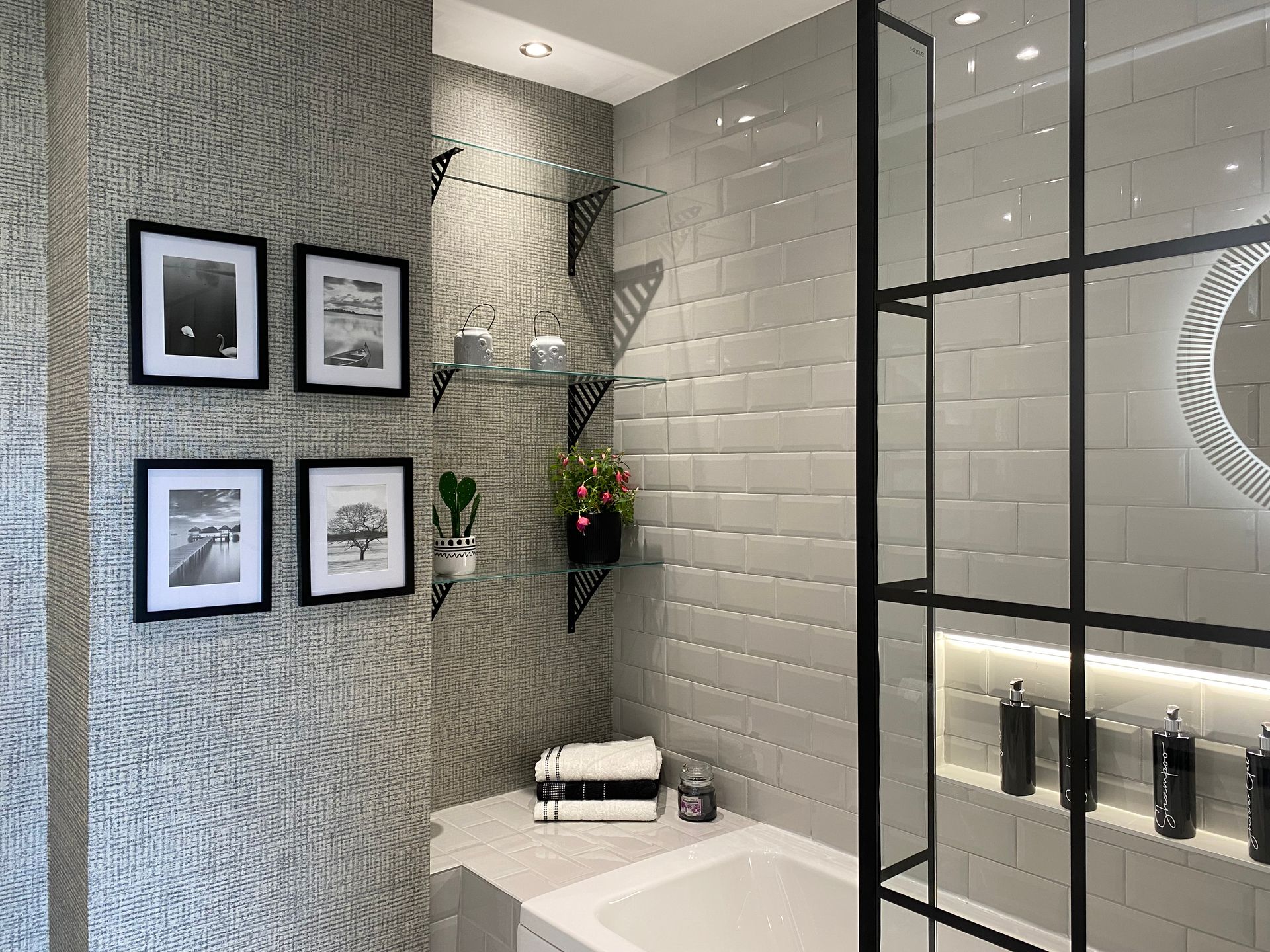 A bathroom with white tiles , a bathtub , a mirror and a shower stall.