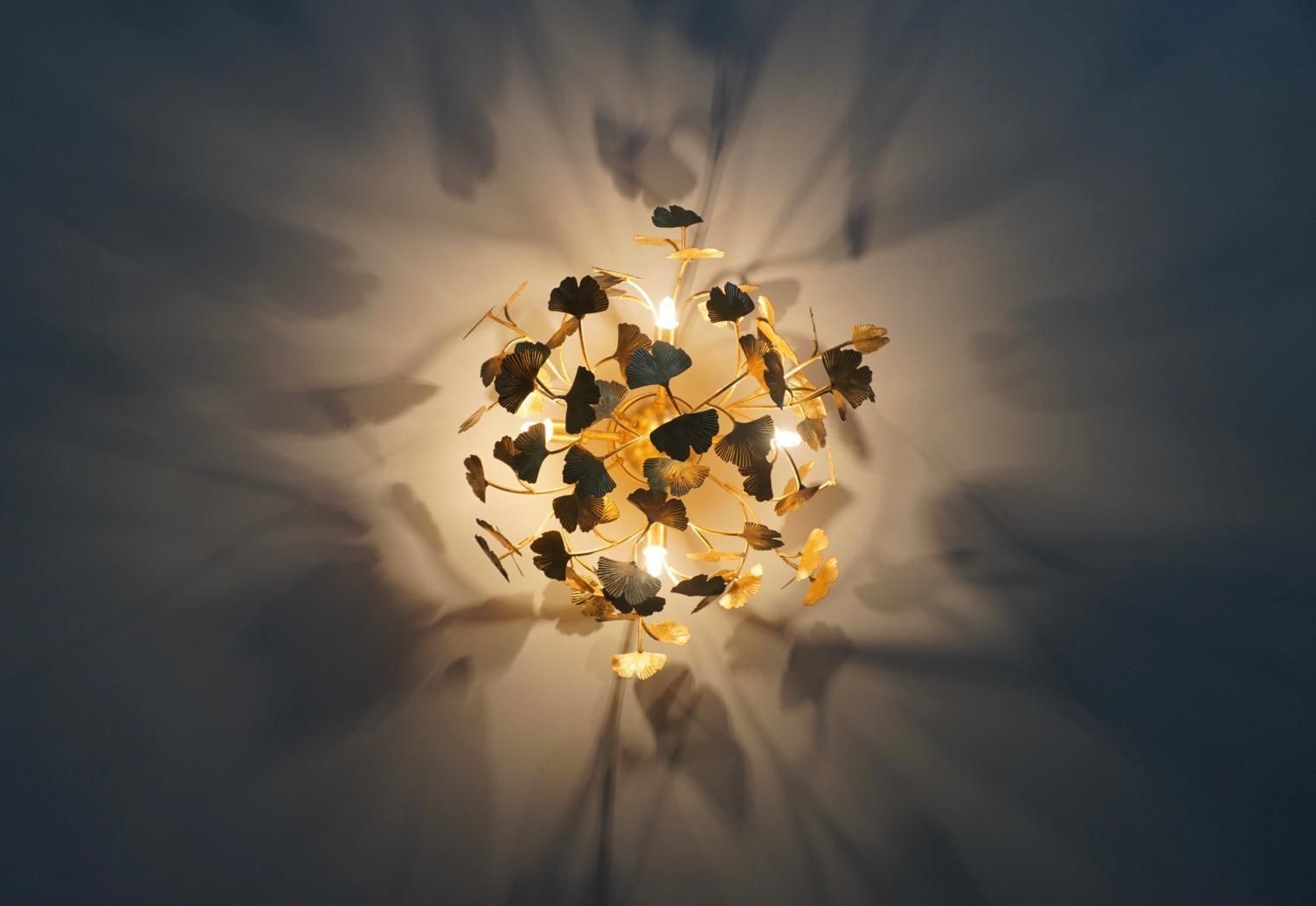 A light with leaves on it is shining on a wall