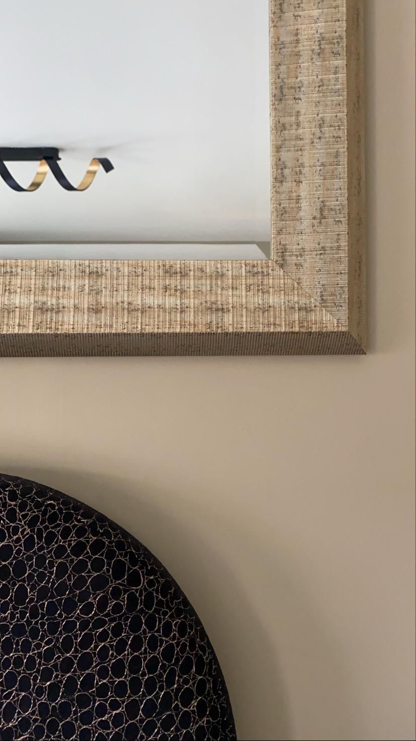 A close up of a mirror and a plate on a wall.