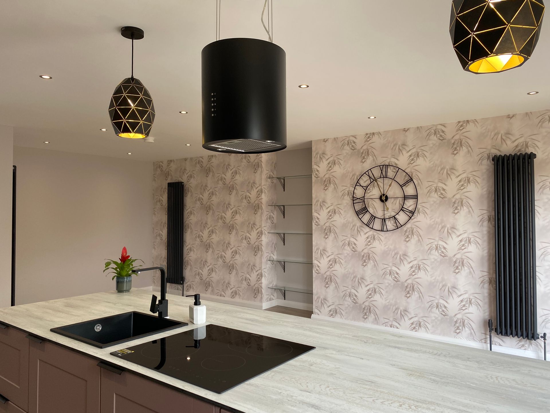 A kitchen with a sink and a clock on the wall