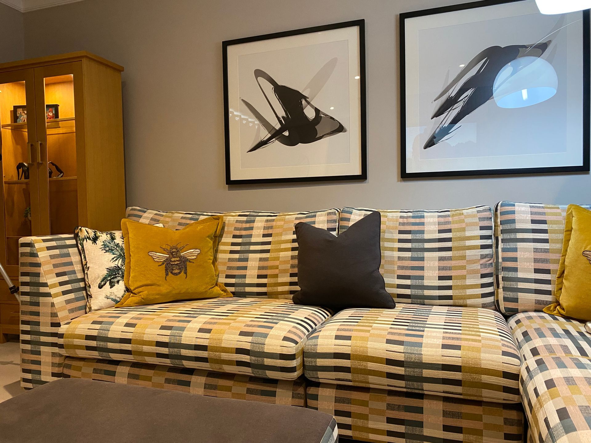 A living room with a couch and two pictures on the wall.