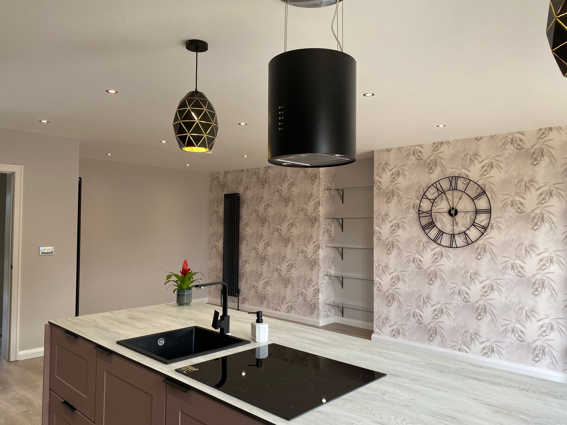 A kitchen with a sink and a clock on the wall.