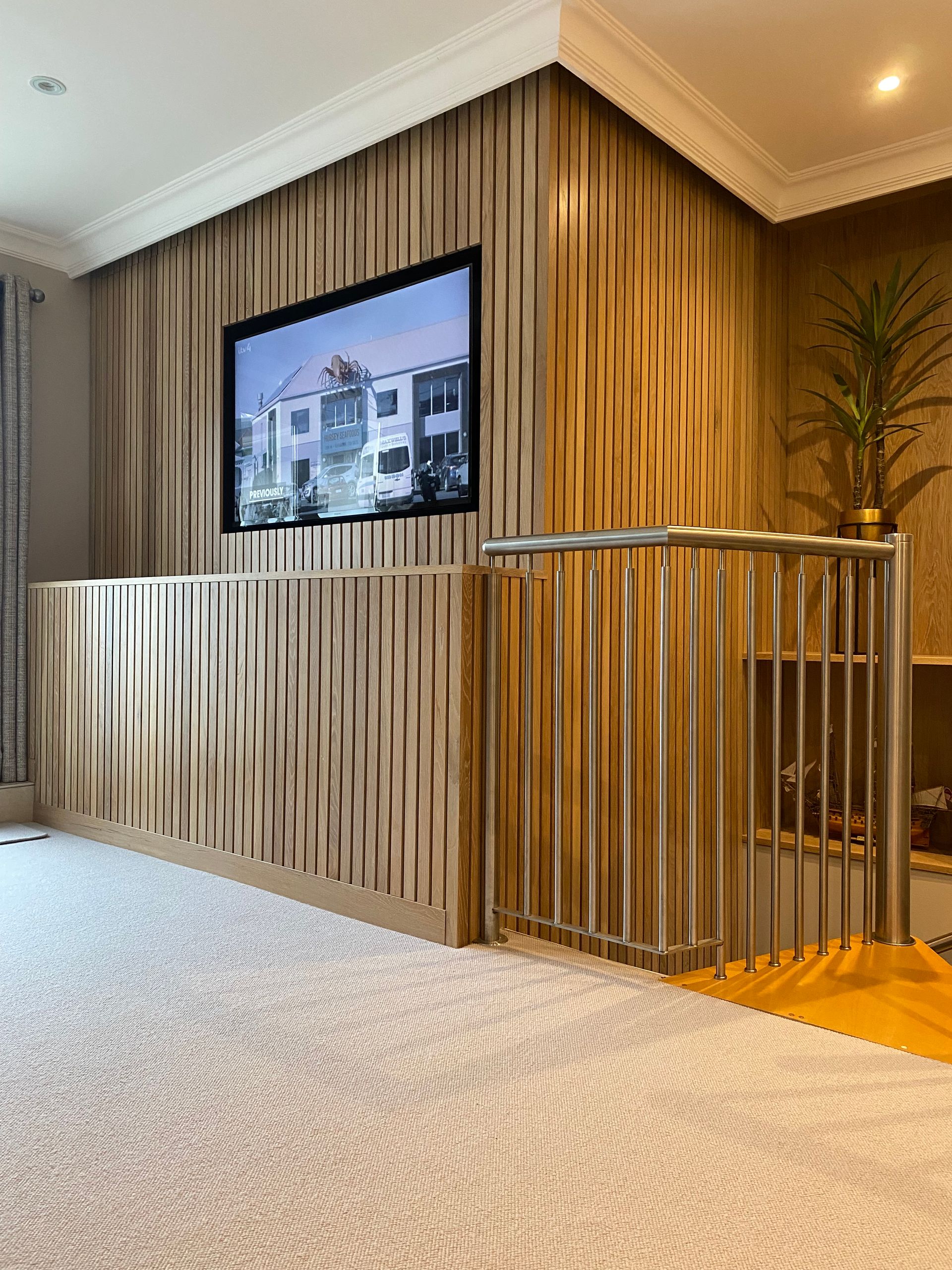 A living room with a wooden wall and a flat screen tv on the wall.