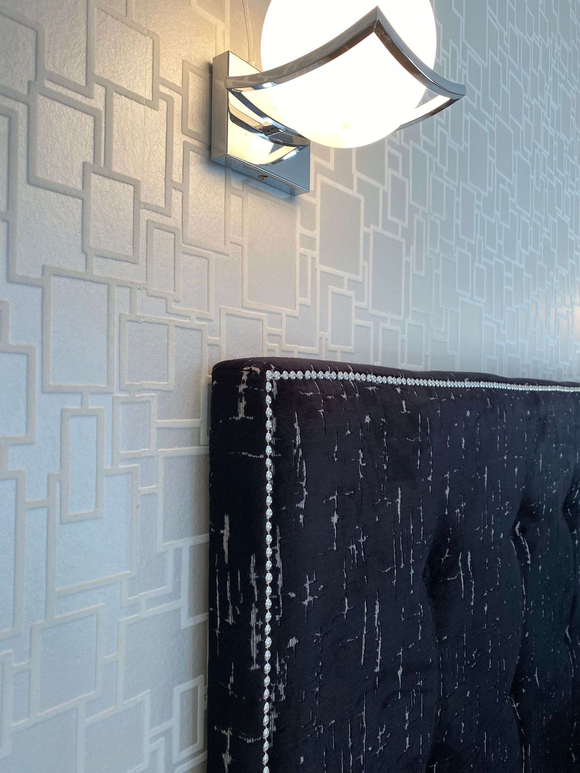 A black headboard with a light above it