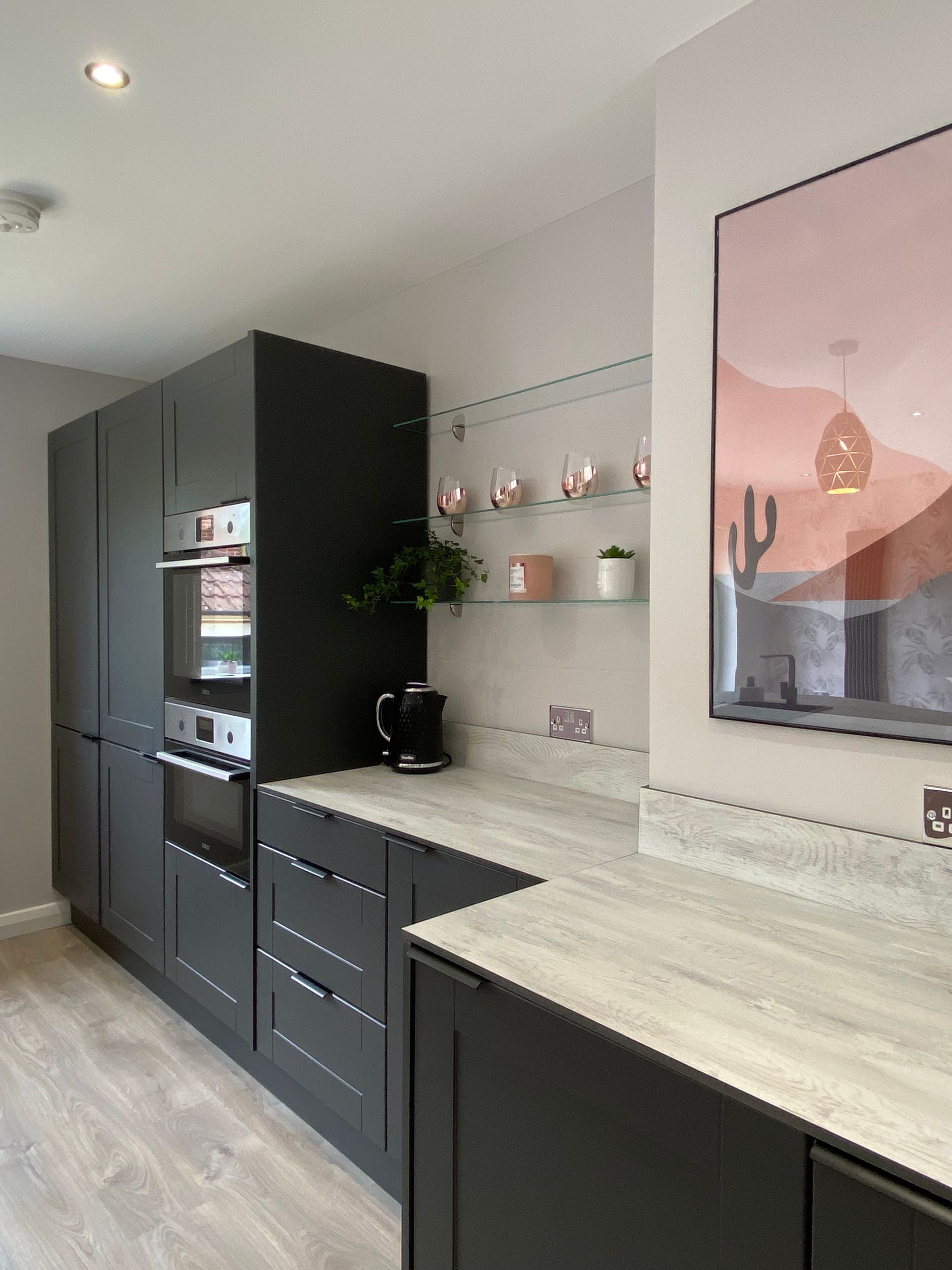 A kitchen with a picture of a cactus on the wall