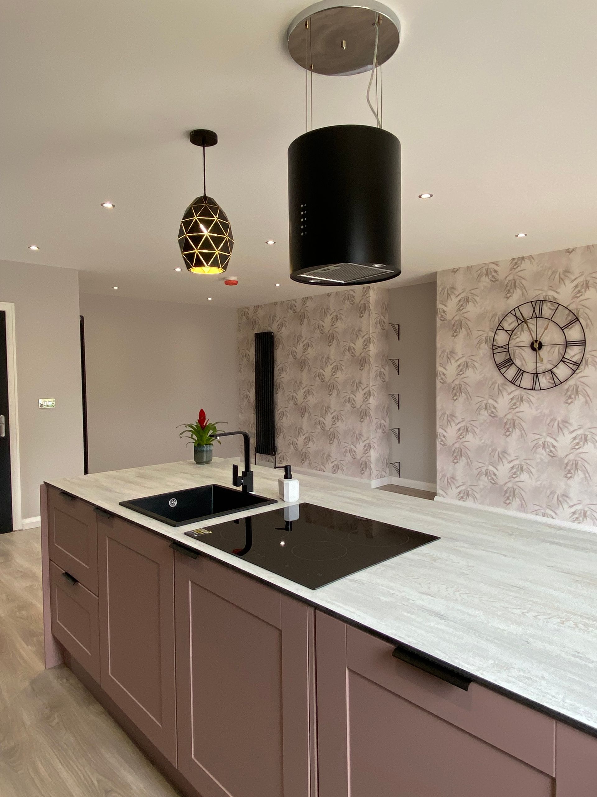 A kitchen with two sinks and a clock on the wall