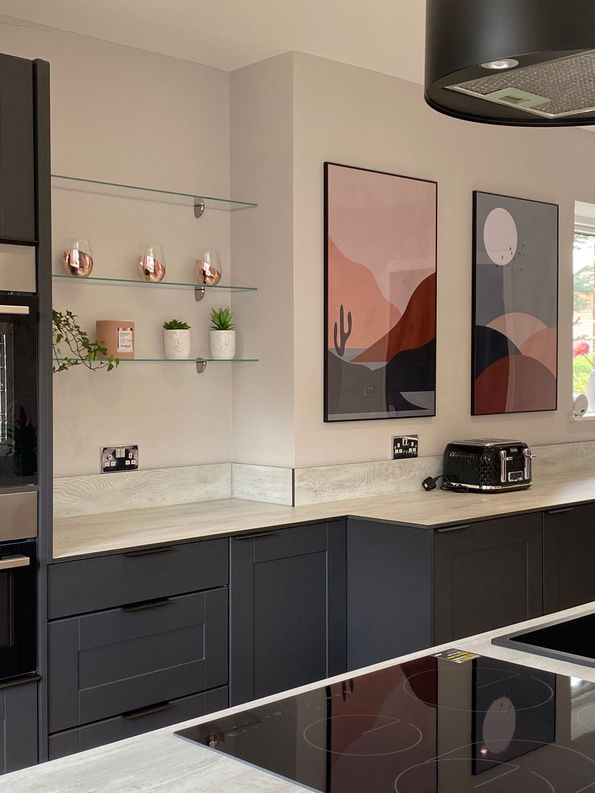 A kitchen with black cabinets and a stove top oven.