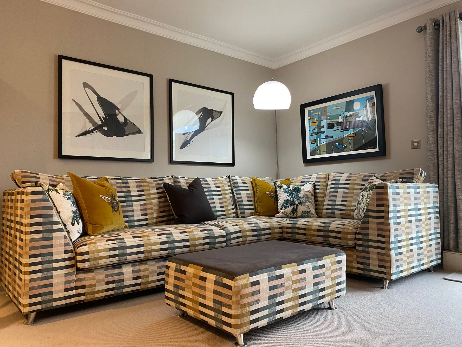 A living room with a large sectional couch and ottoman