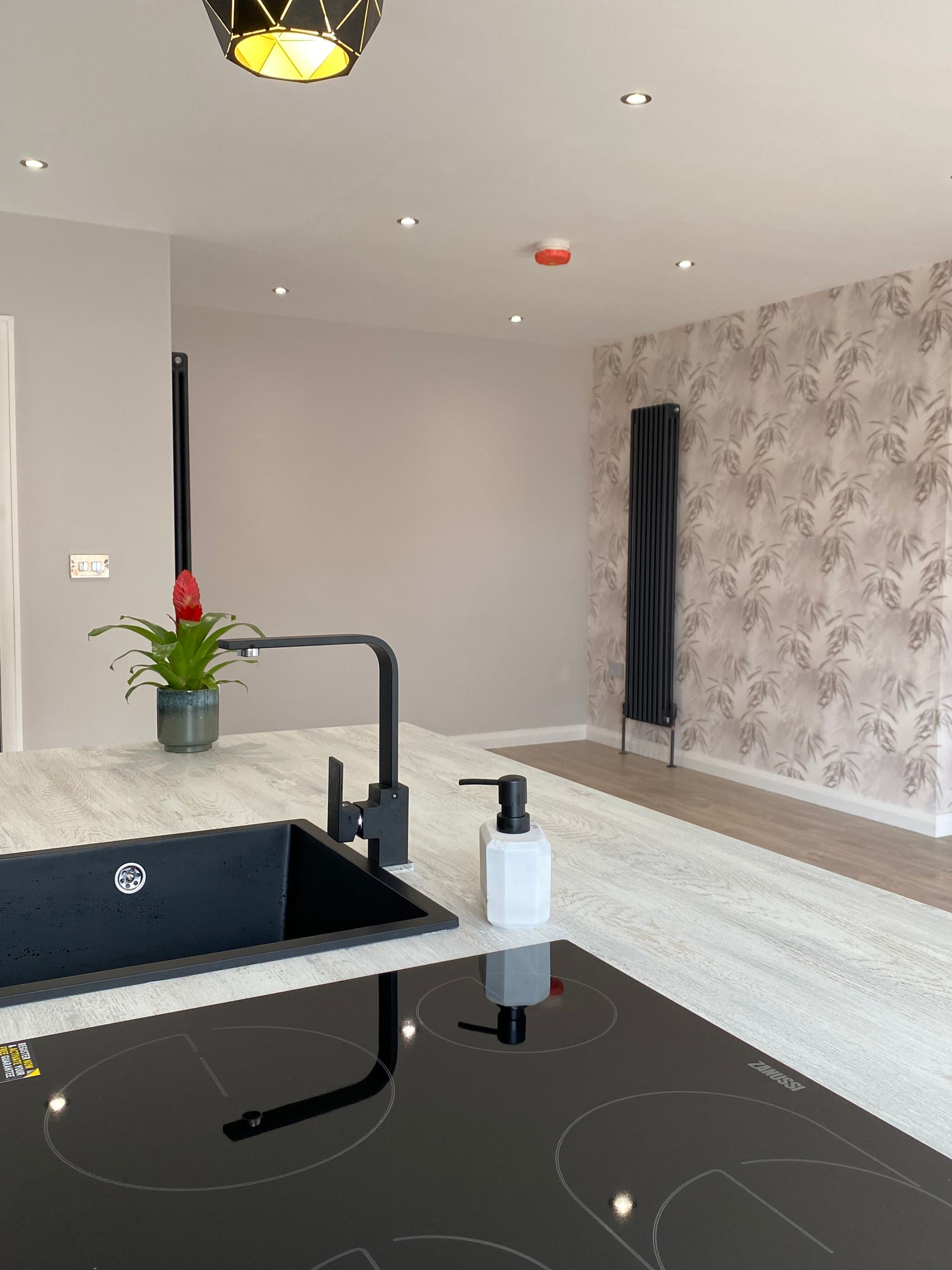 A kitchen with a sink and a stove top oven.