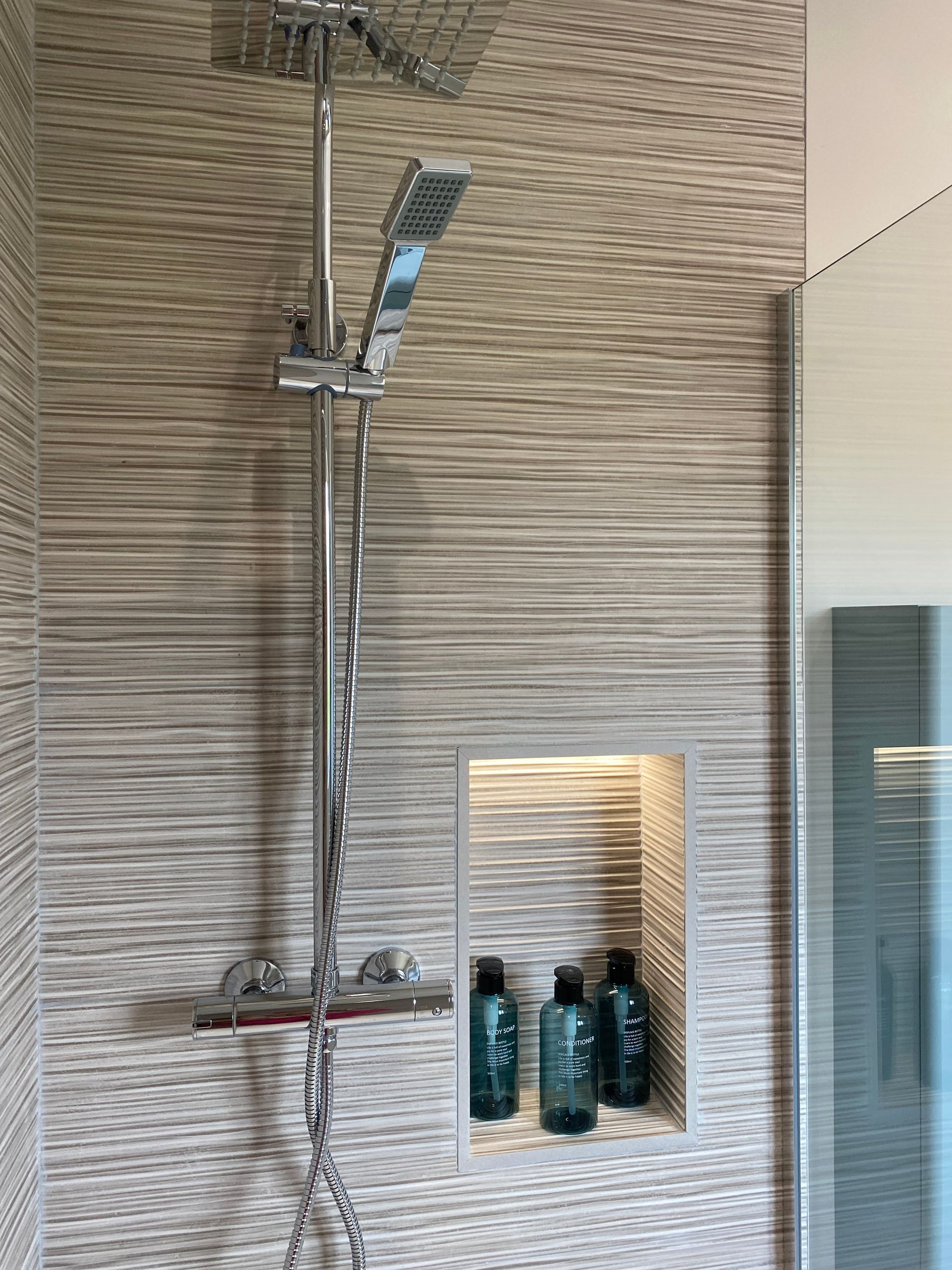 A shower head is hanging from the ceiling in a bathroom.