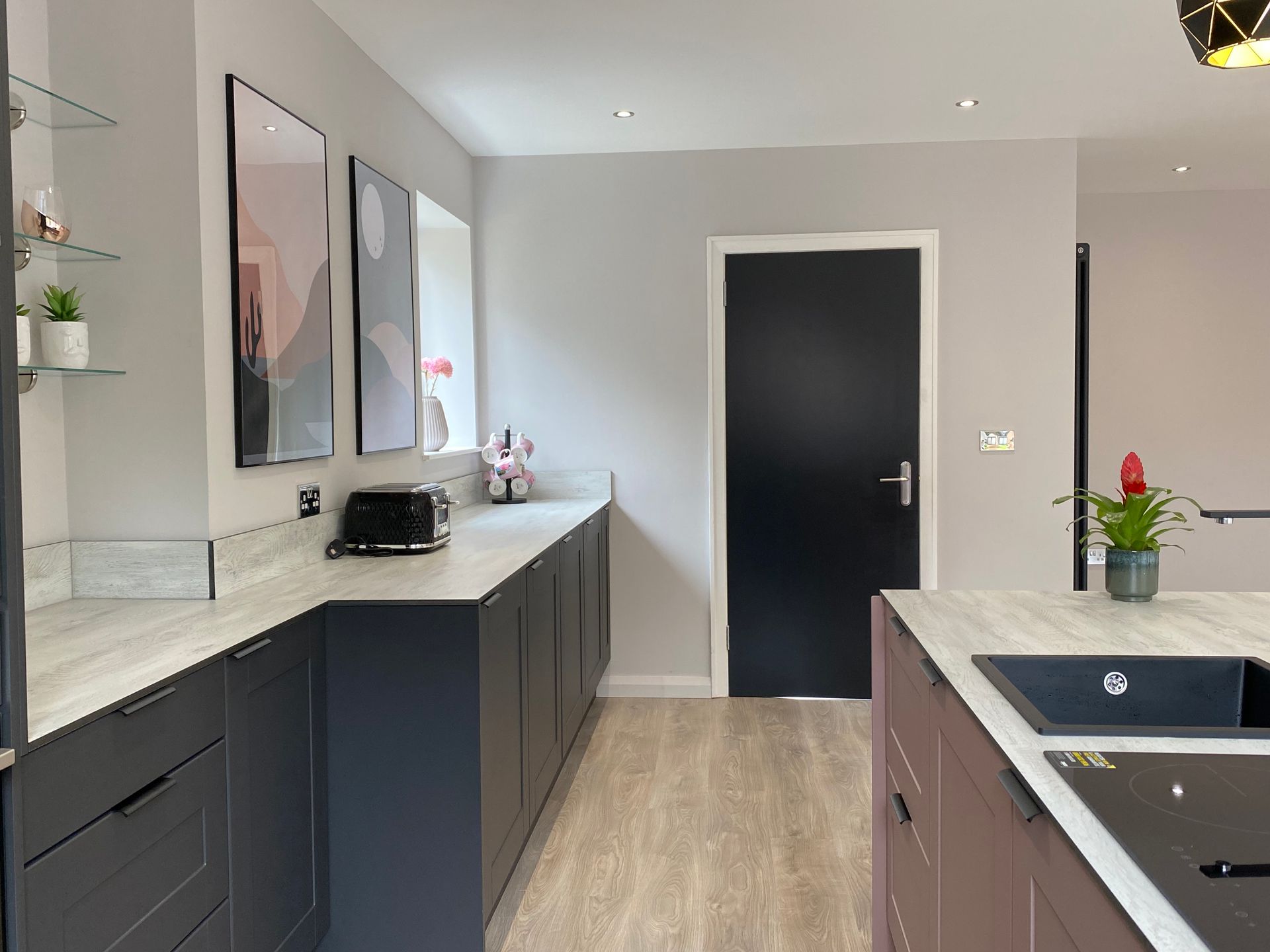 A kitchen with a black door and a sink