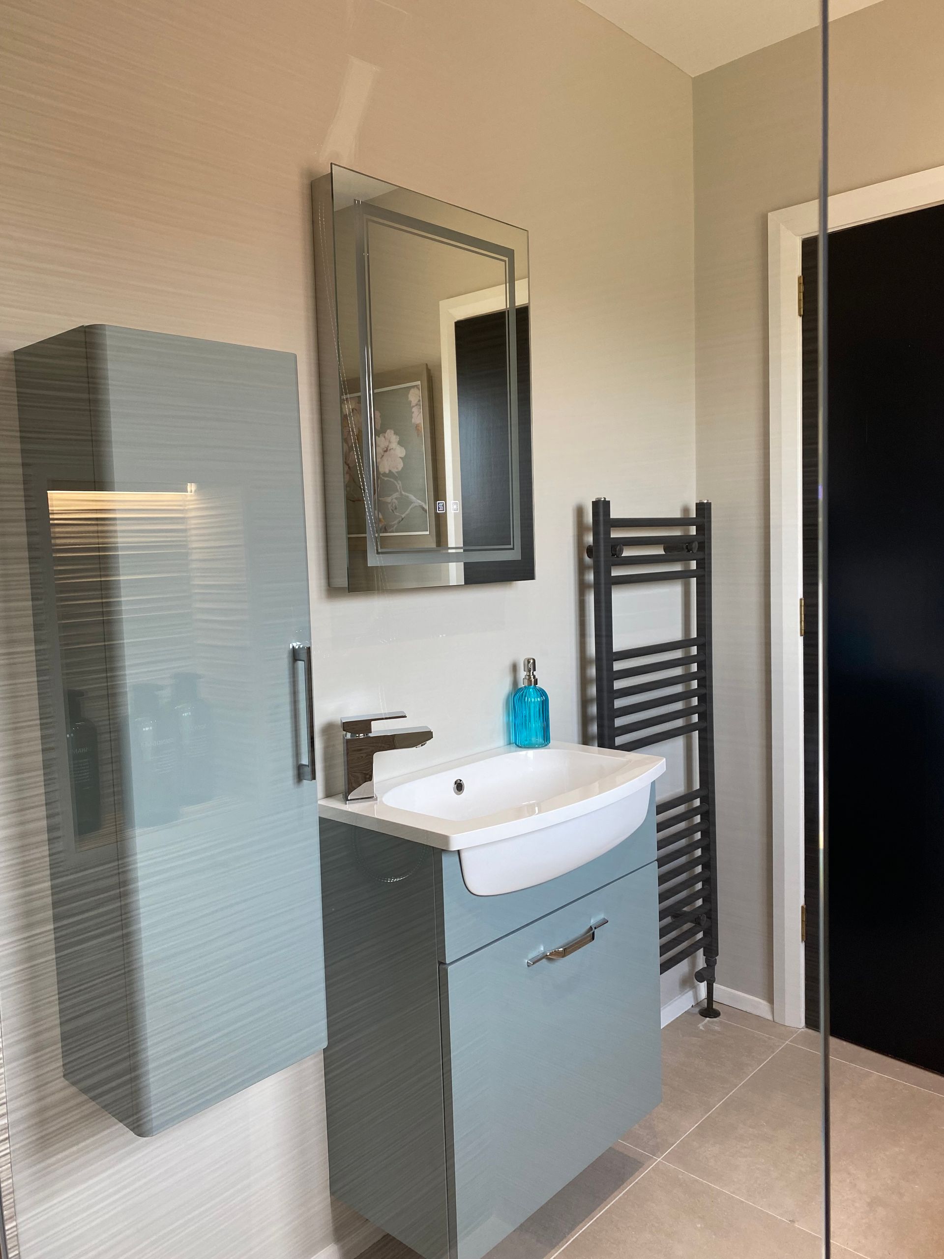 A bathroom with a sink , mirror and towel rack