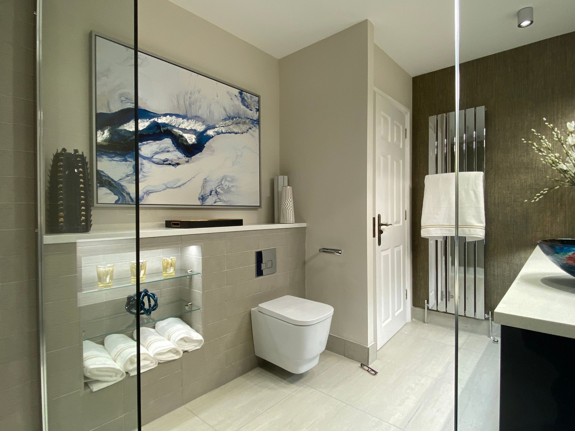 A bathroom with a toilet and a painting on the wall.